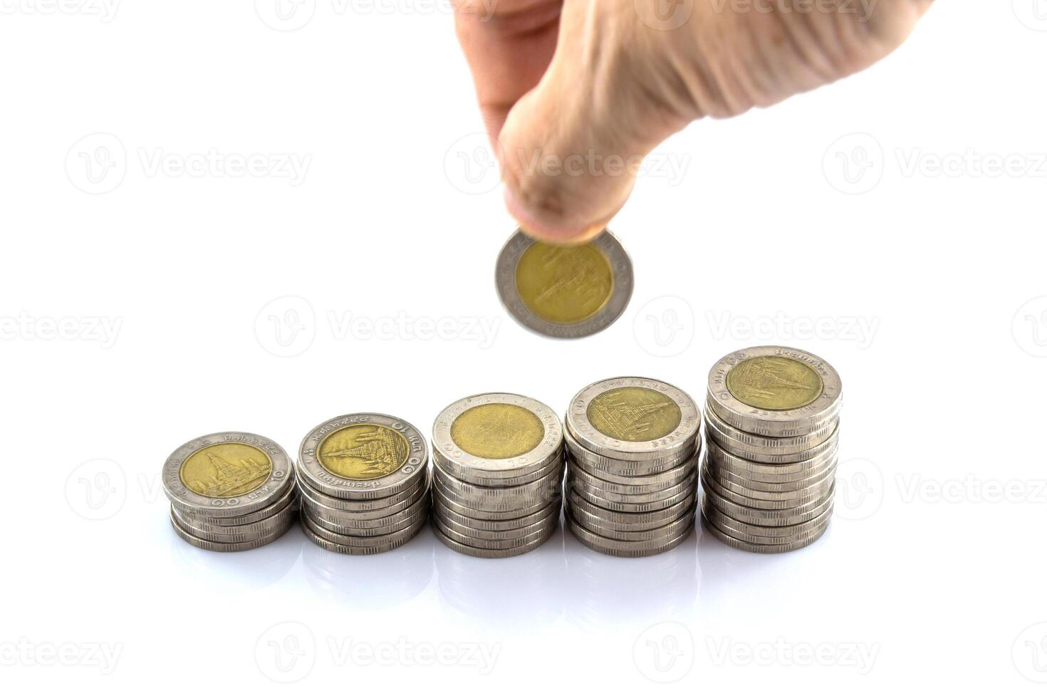 Hand holding a stack of coins with a coin in the middle photo
