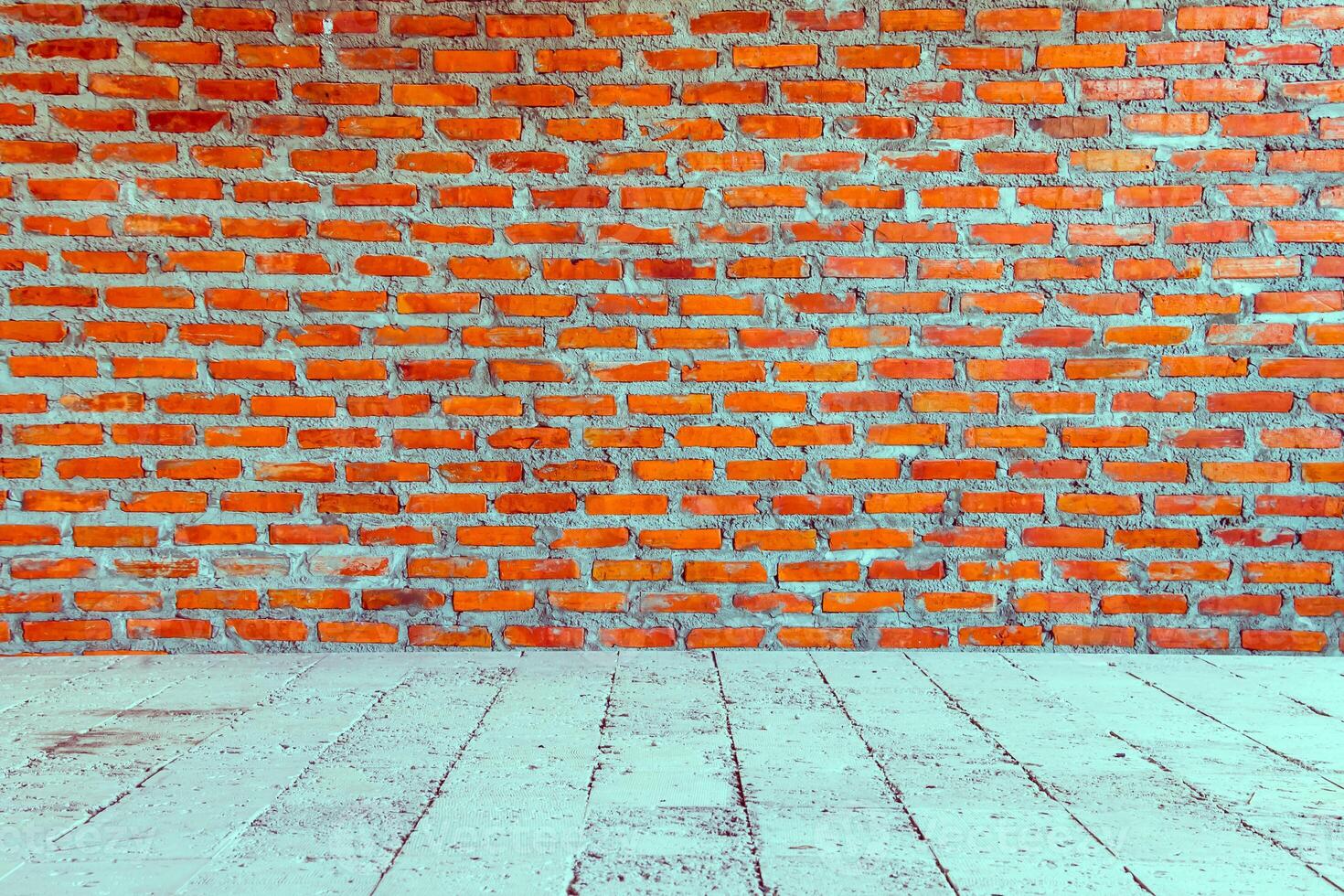 An empty room with a brick wall and wooden floor photo