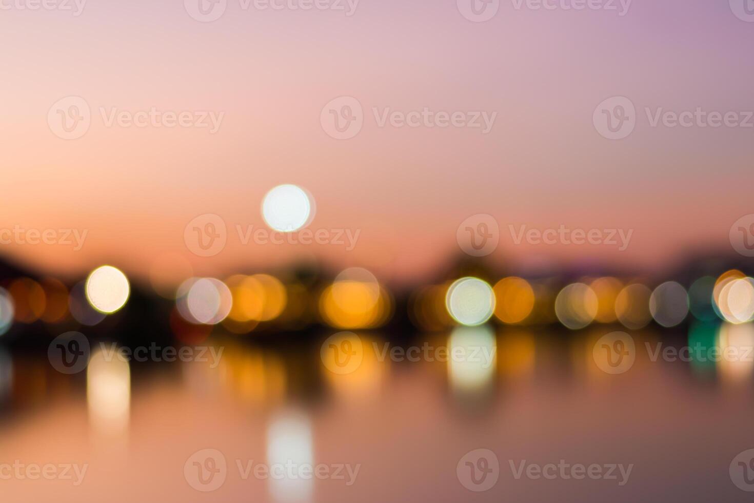 Blurred bokeh light background of the city at sunset photo