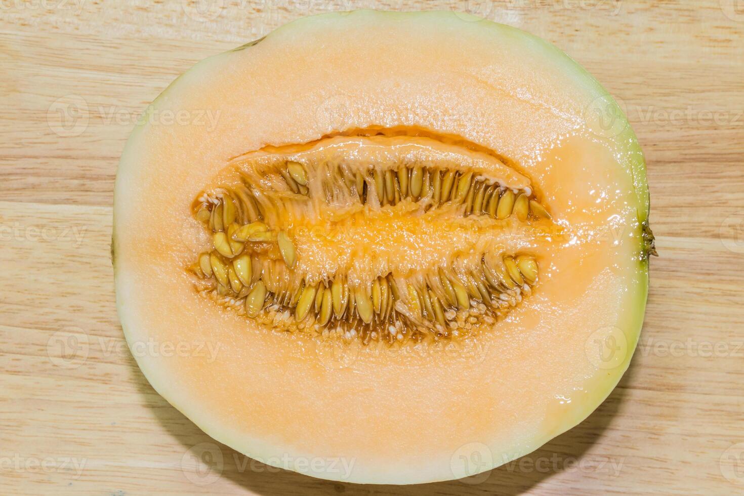 A cut open melon on a wooden surface photo