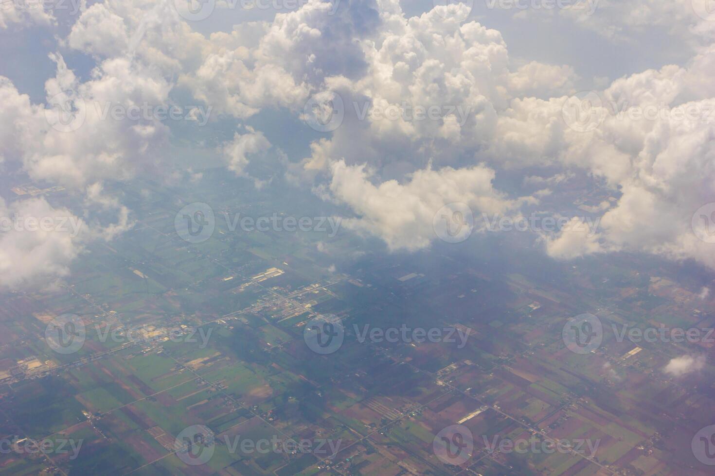 A view of a cloudy sky and a plane flying through it photo