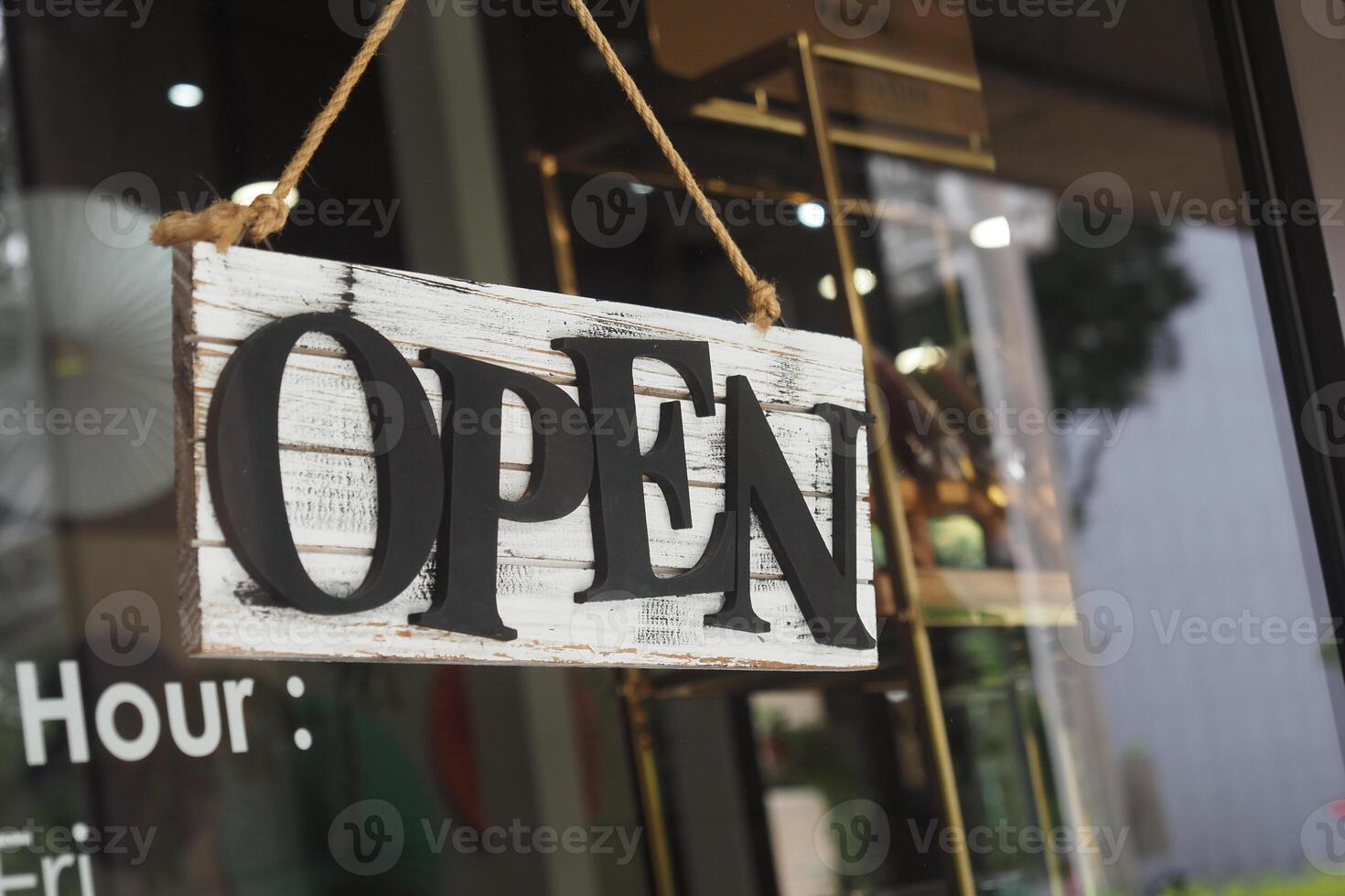 Open sign hanging at a store entrance during daytime photo