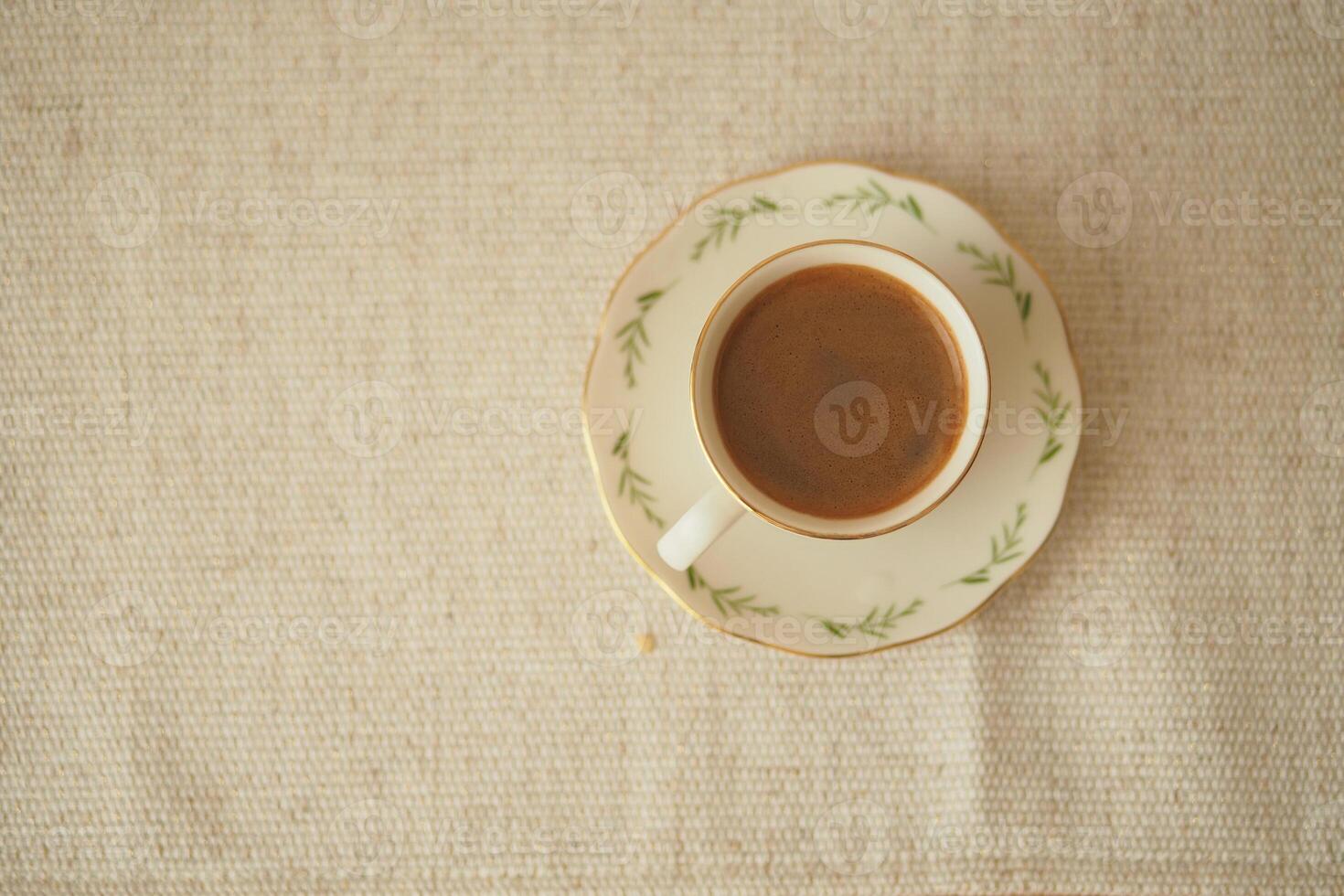 Coffee cup on a simple table setting in morning light photo