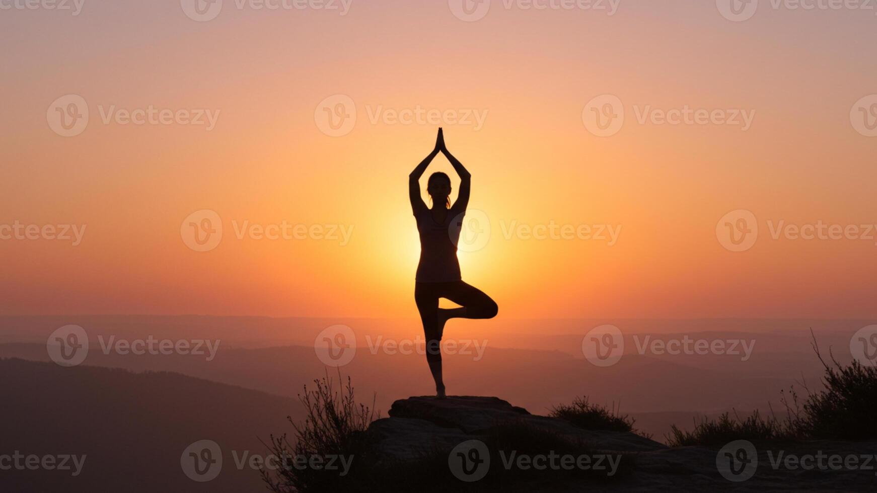 Woman practicing yoga tree pose silhouette at beautiful sunset photo