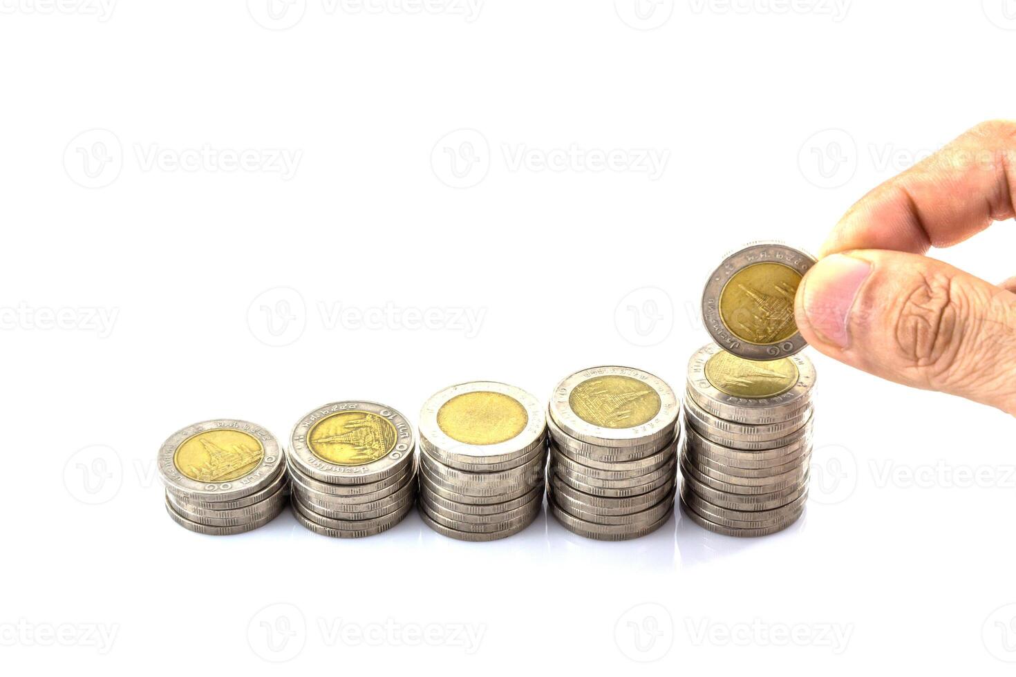 A hand is holding a stack of coins with a coin in the middle photo