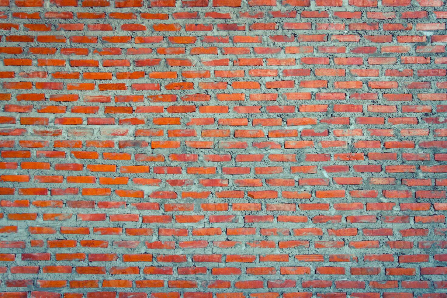 A brick wall with red bricks and a few small squares photo