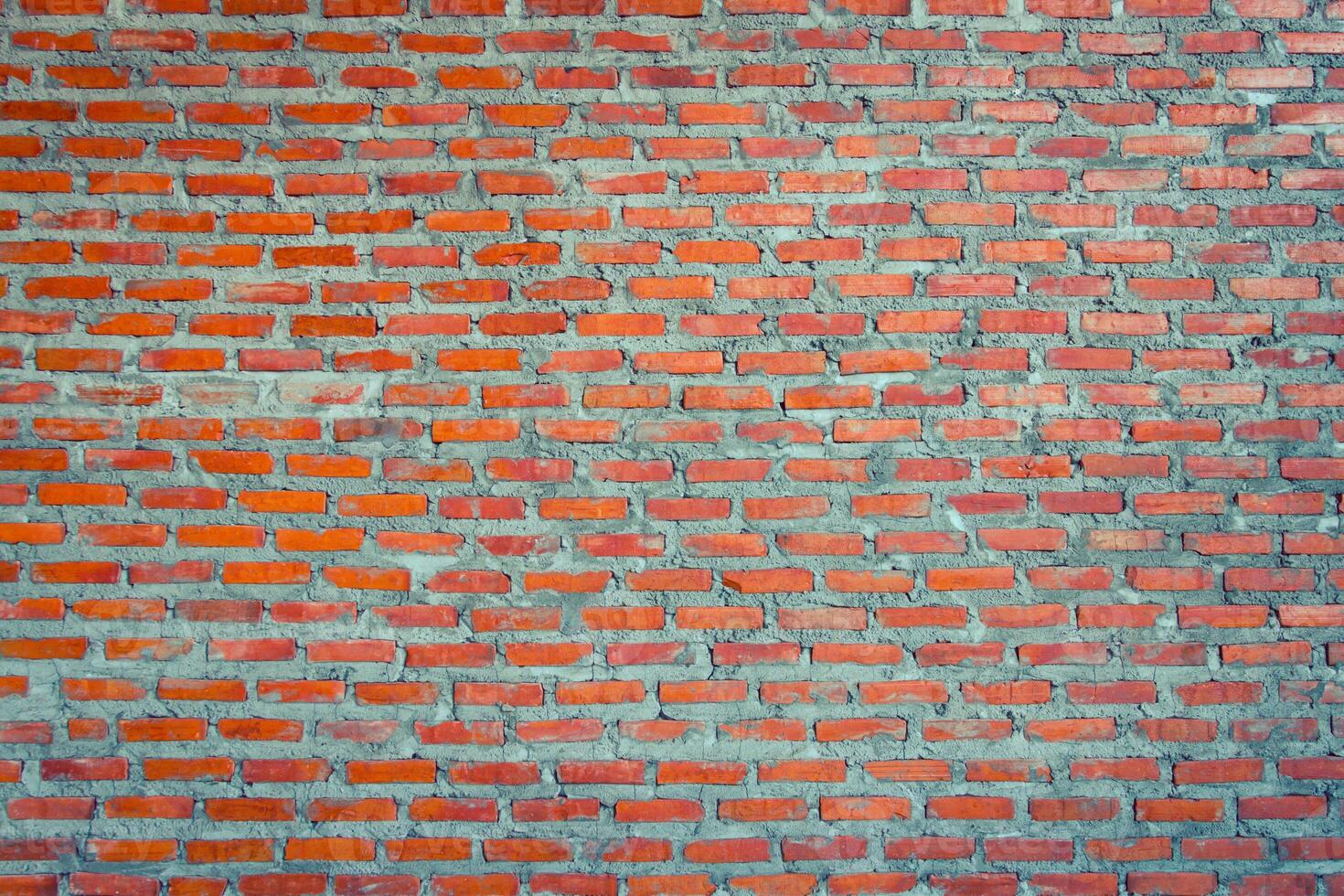 A brick wall with red bricks and a few small holes photo
