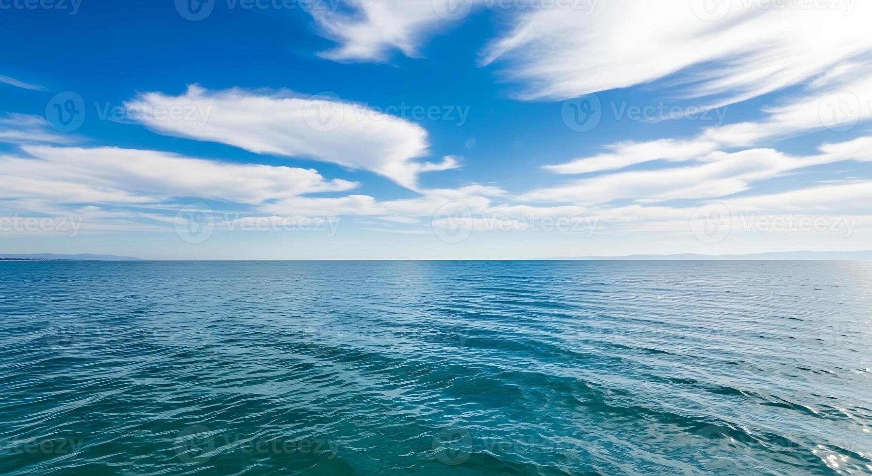 Vast Blue Ocean Meeting the Horizon Under a Sky Filled with Wispy White Clouds photo
