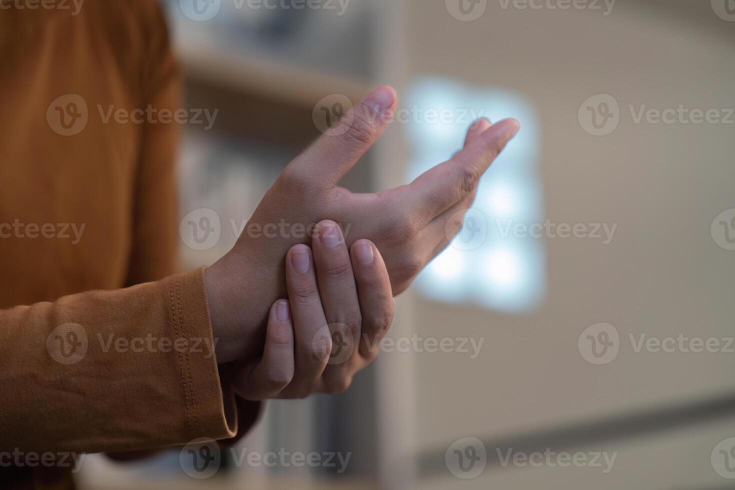 Wrist Pain Relief. Individual holding wrist, experiencing discomfort. photo