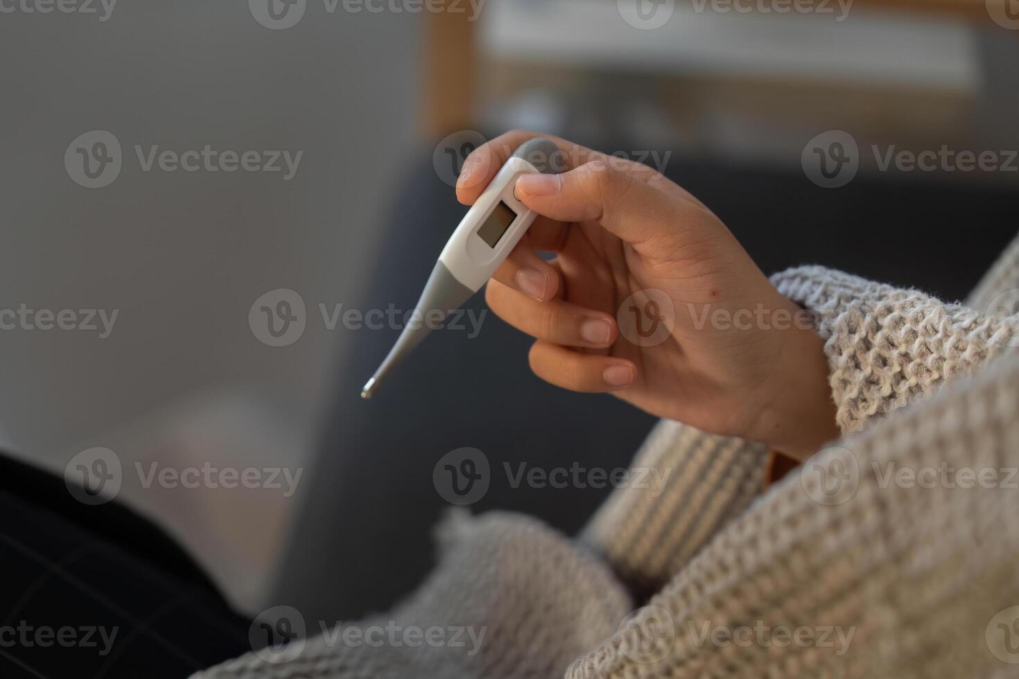 Fever Monitoring. Individual checking temperature with thermometer. photo