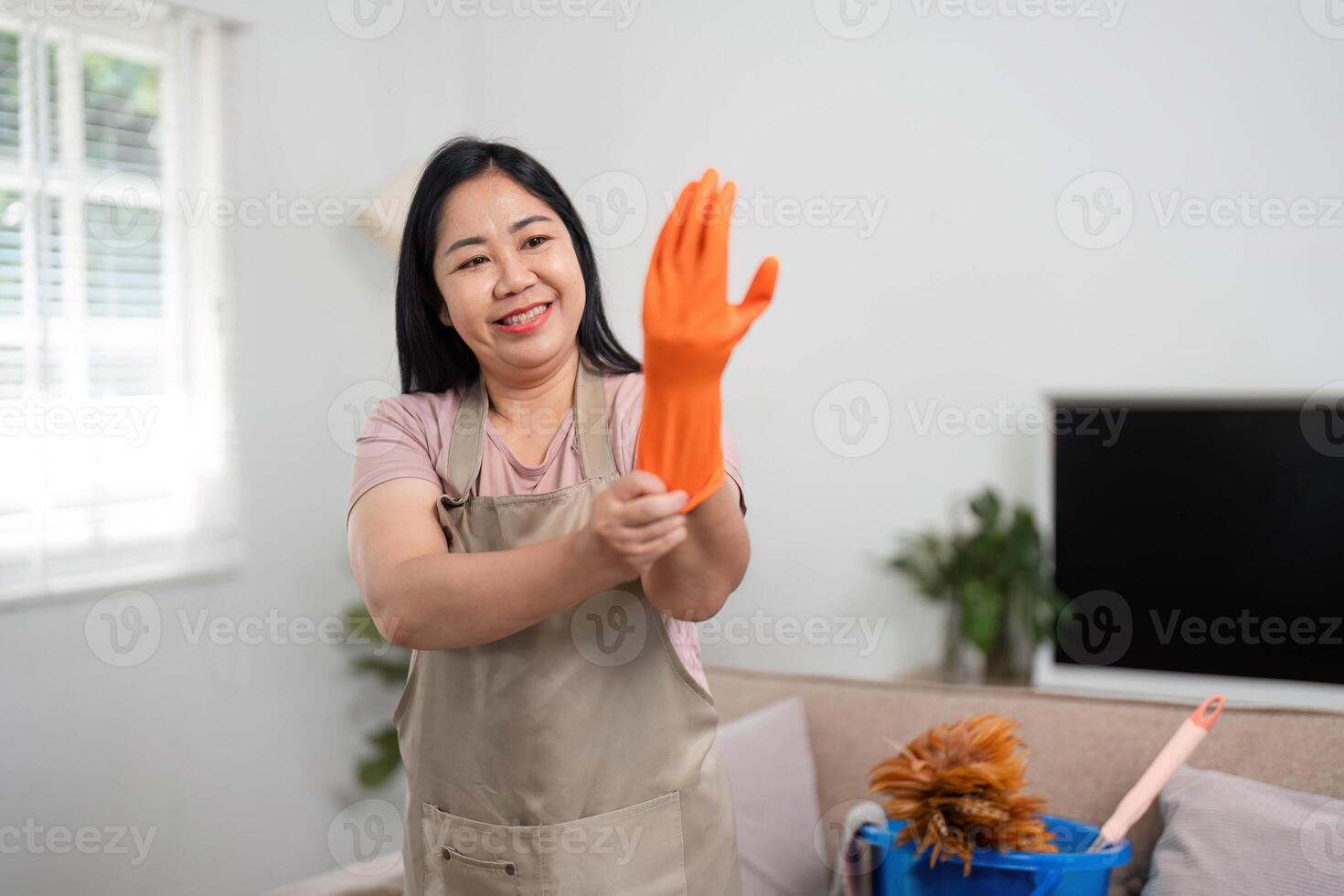 Cleaning and Home Care. A woman preparing for house cleaning by putting on rubber gloves. photo
