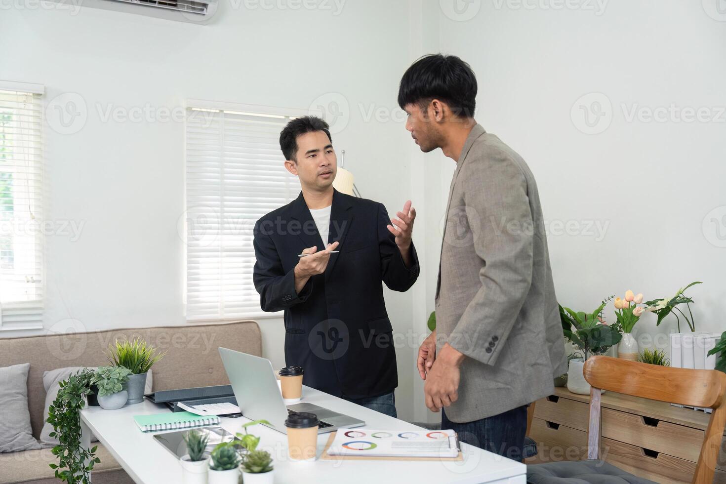 Professional Discussion and Strategy Planning. Two men in a modern office discussing project details and strategies. photo