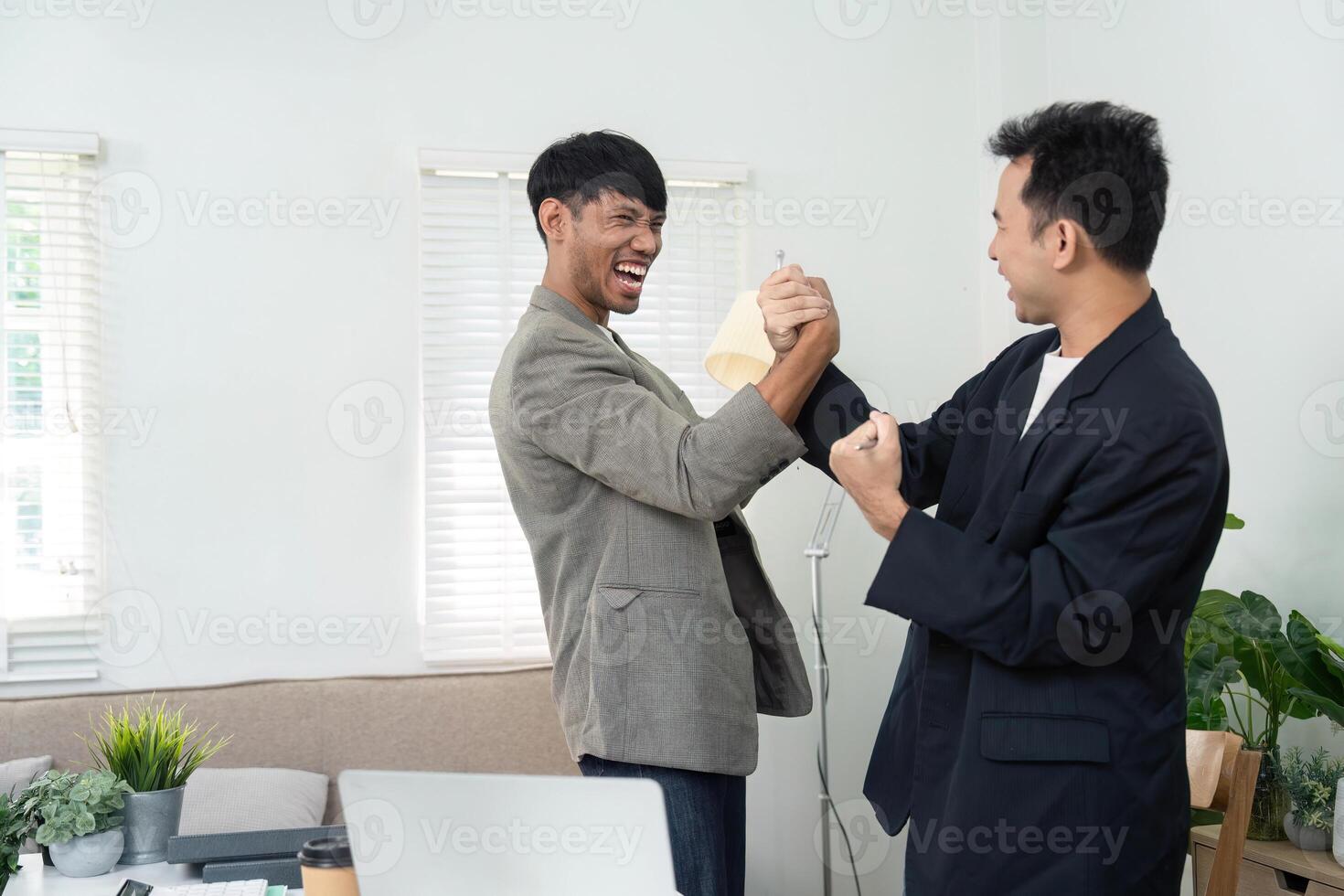 Friendly Competition and Engagement. Two men playfully engaging in an arm wrestling match at the office. photo