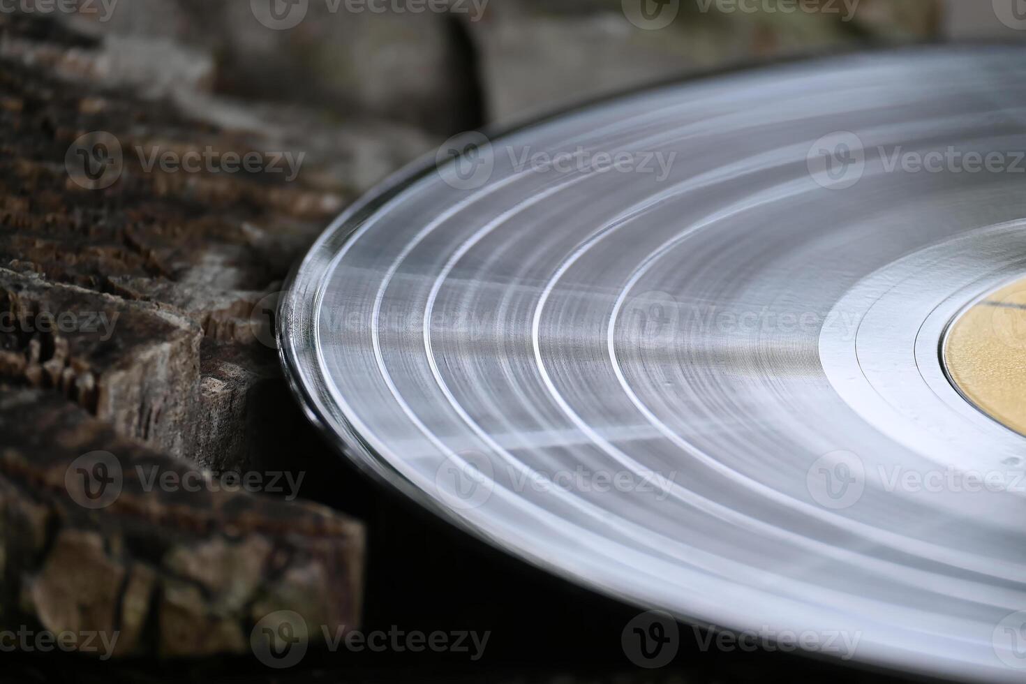 A close-up shot of a vintage vinyl record resting on weathered wood, evoking a nostalgic feel. photo
