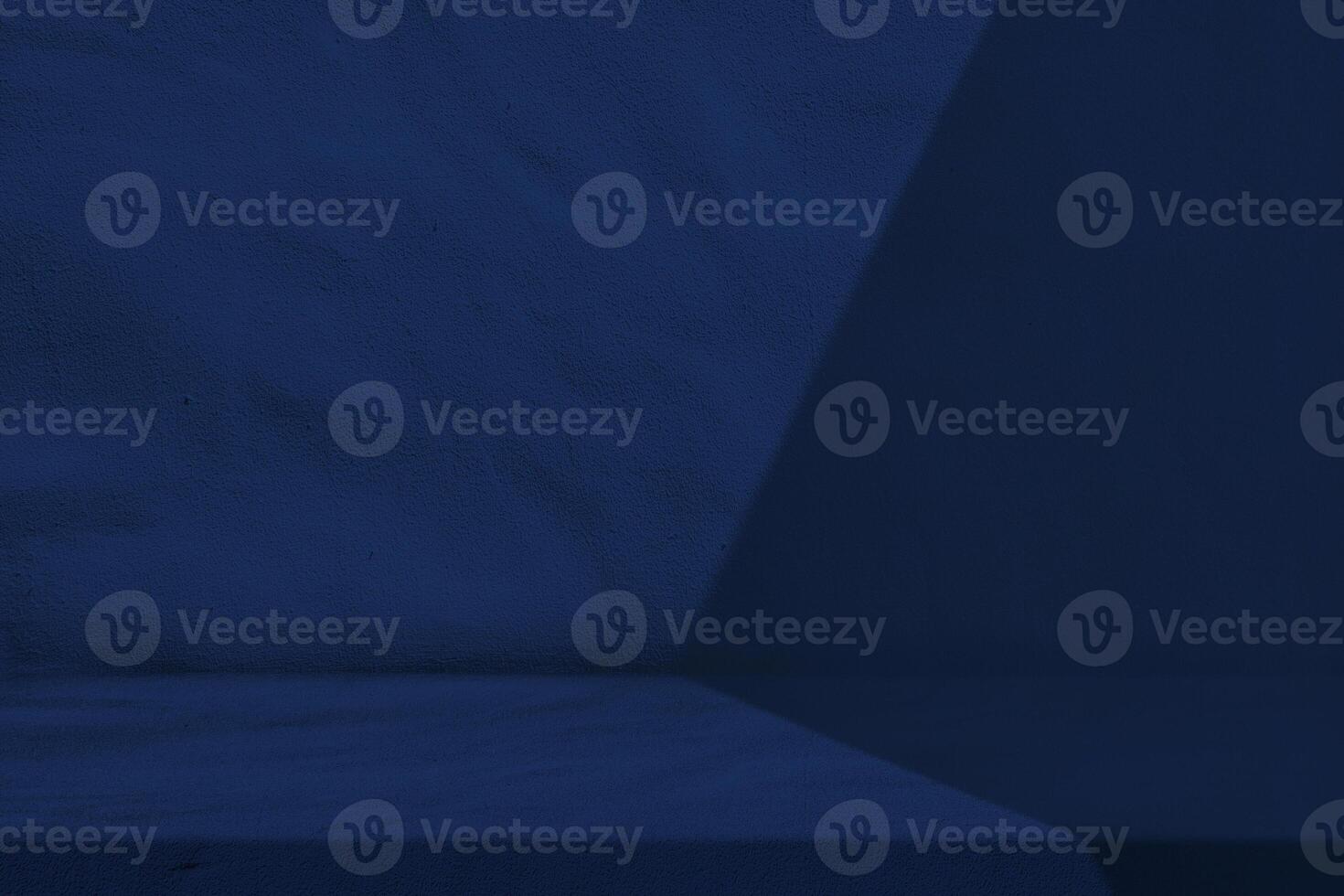 Table with Light Beam and Shadow on Dark Blue Wall Background photo