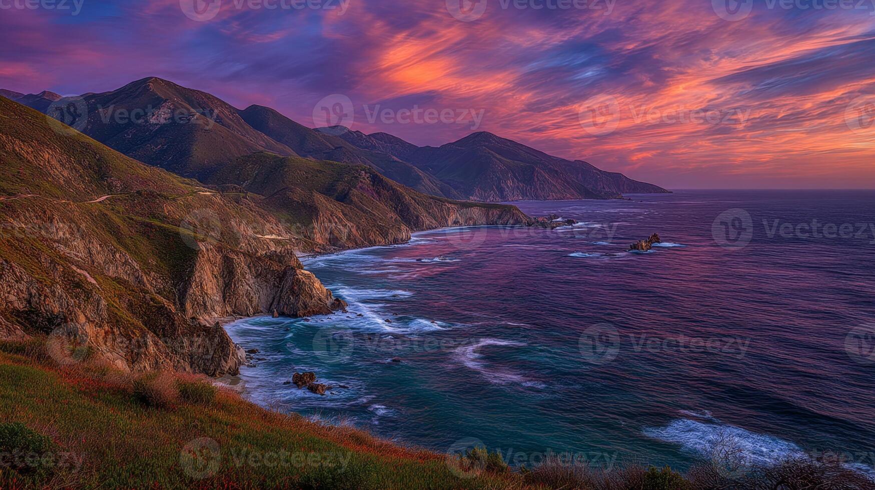 Serene Coastal Landscape at Dusk with Vibrant Sky Over Mountain Ranges and Gentle Waves Lapping on Rocky Shoreline photo