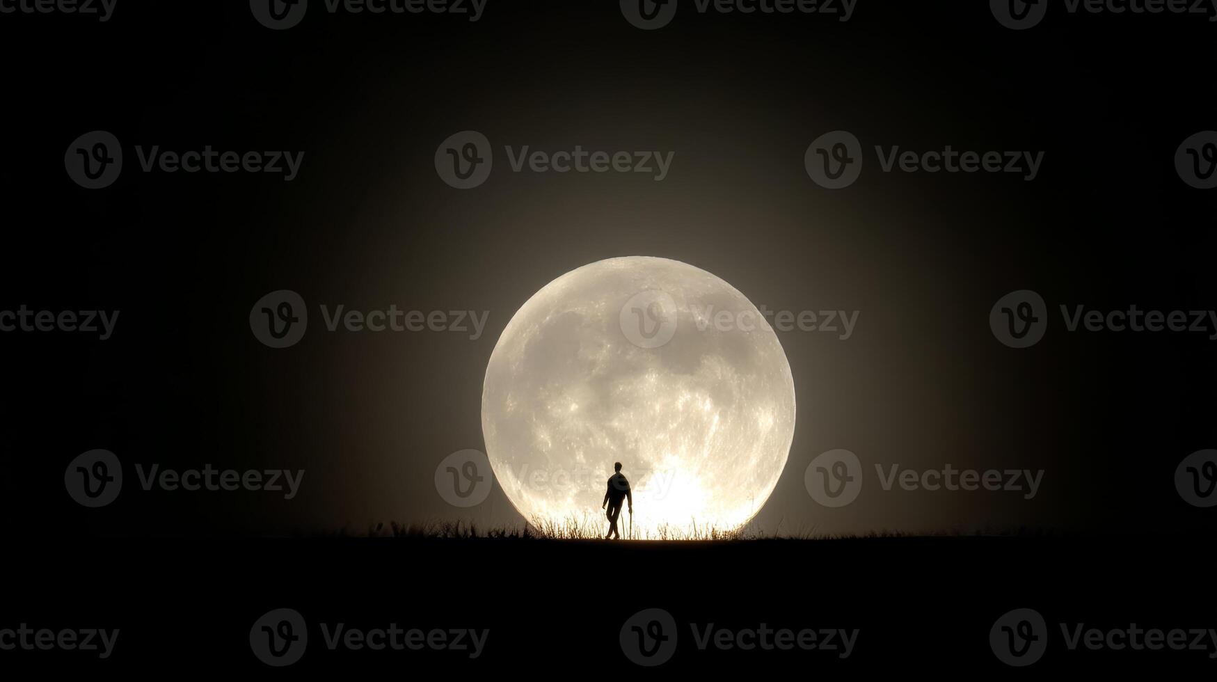 Silhouette of a Person Against a Large Full Moon in a Starry Night Sky photo