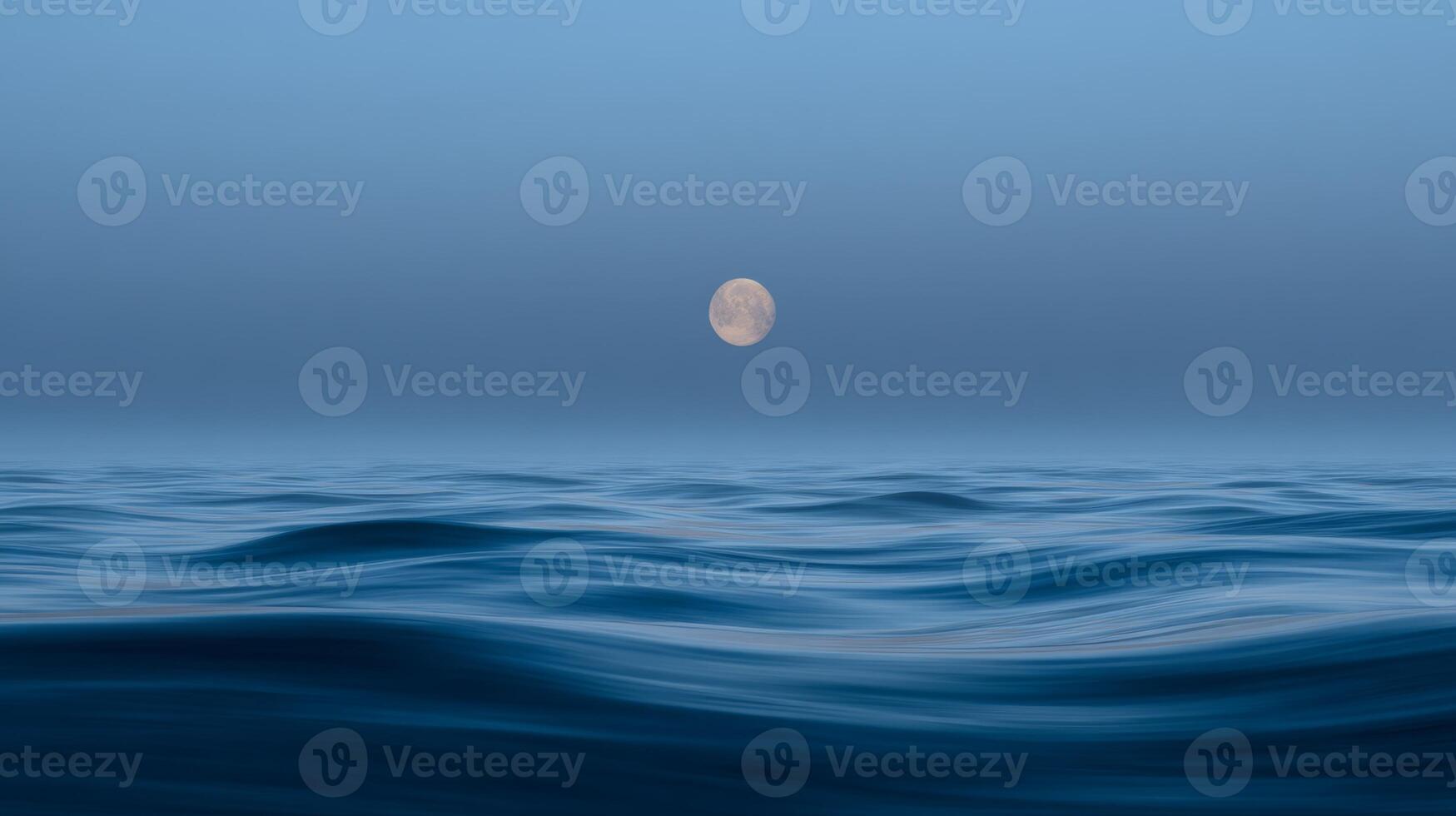 Serene Ocean Waves Under a Full Moon in a Tranquil Night Sky photo