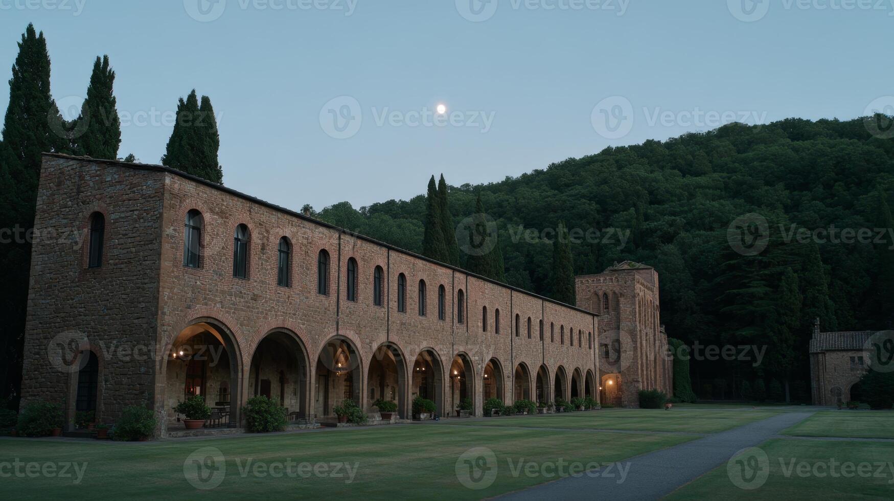 Tranquil Evening at Historic Abbey Surrounded by Lush Green Hills and Moonlight Glowing in the Sky photo