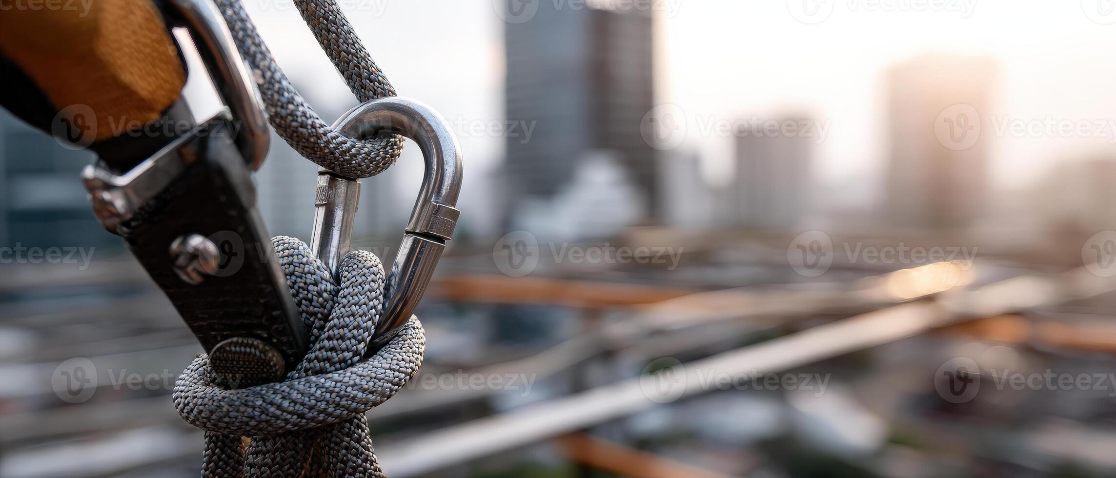 Construction worker safety harness and carabiner on a highrise building site Concept of occupational safety, fall protection, and urban development photo