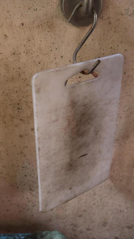 An old plastic cutting board with signs of use and stains, could introduce germs into food photo