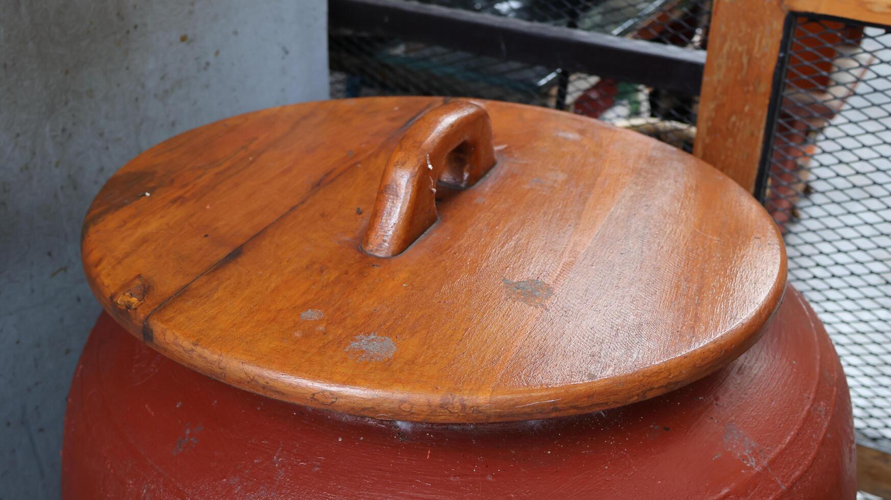 Ancient Asian-style wooden lid for water jars photo