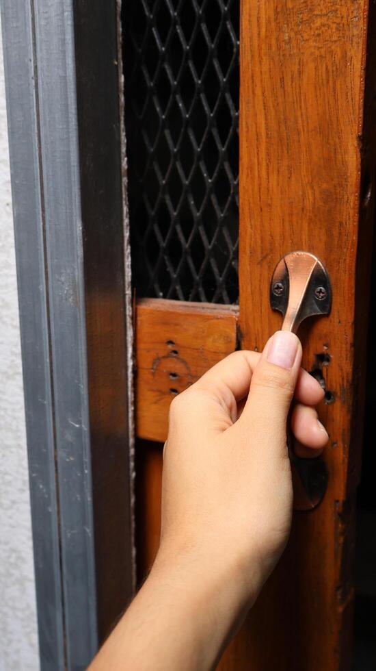 Hand Opening an Old Wooden Door with a Vintage Latch photo