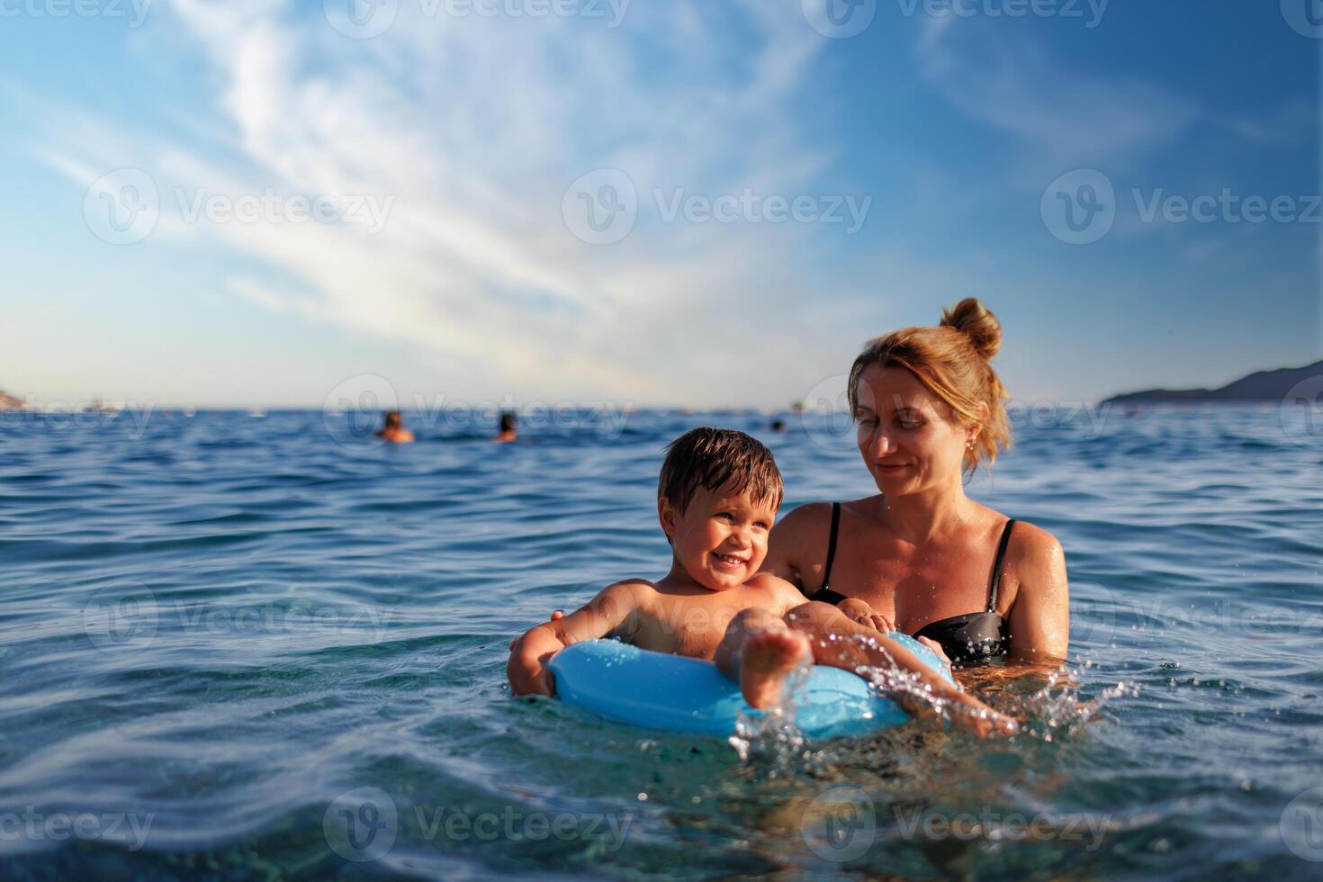 Mother son on inflatable ring sea photo
