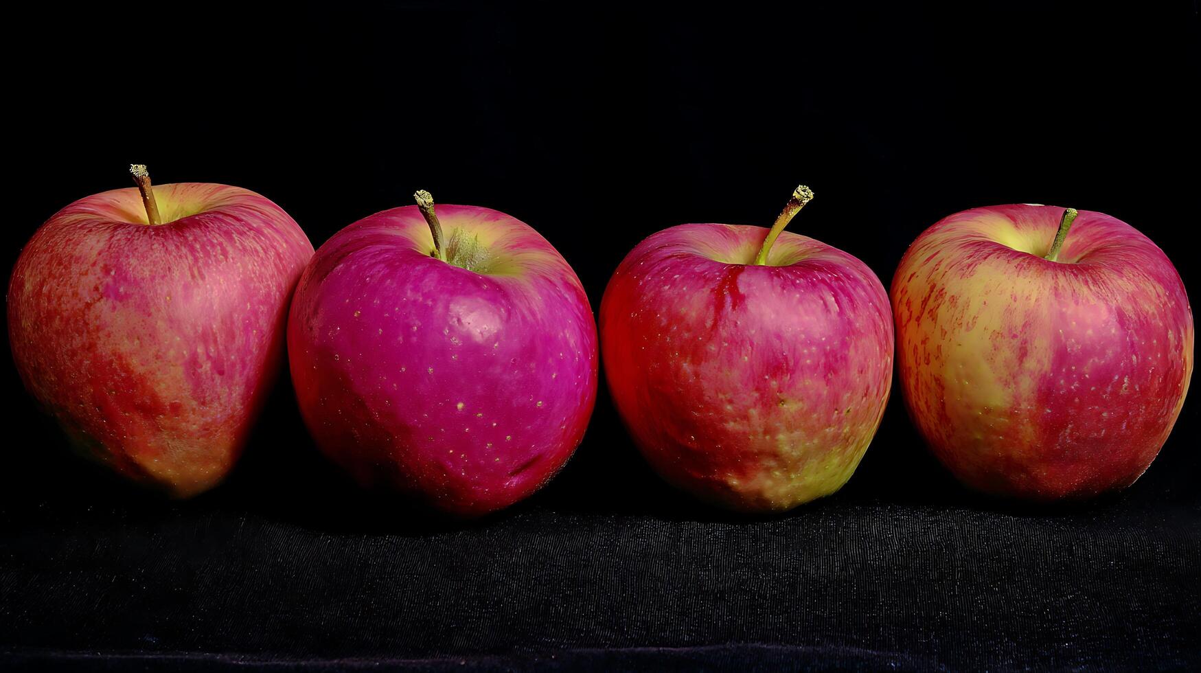 Four Red Apples Lined Up Against a Dark Background. photo