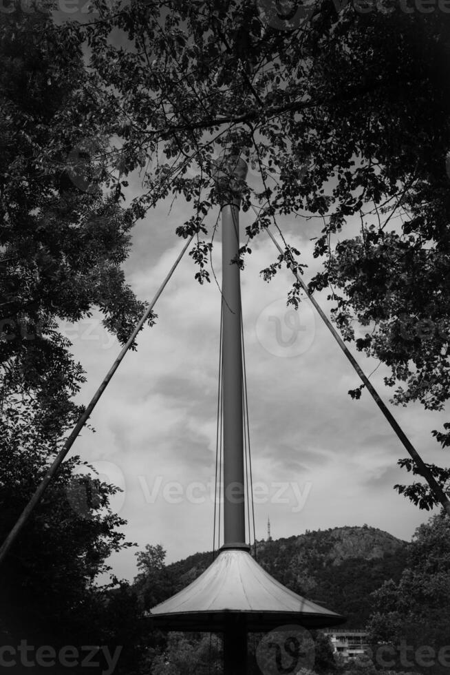 Towering structure surrounded by trees under a cloudy sky in a serene park setting photo