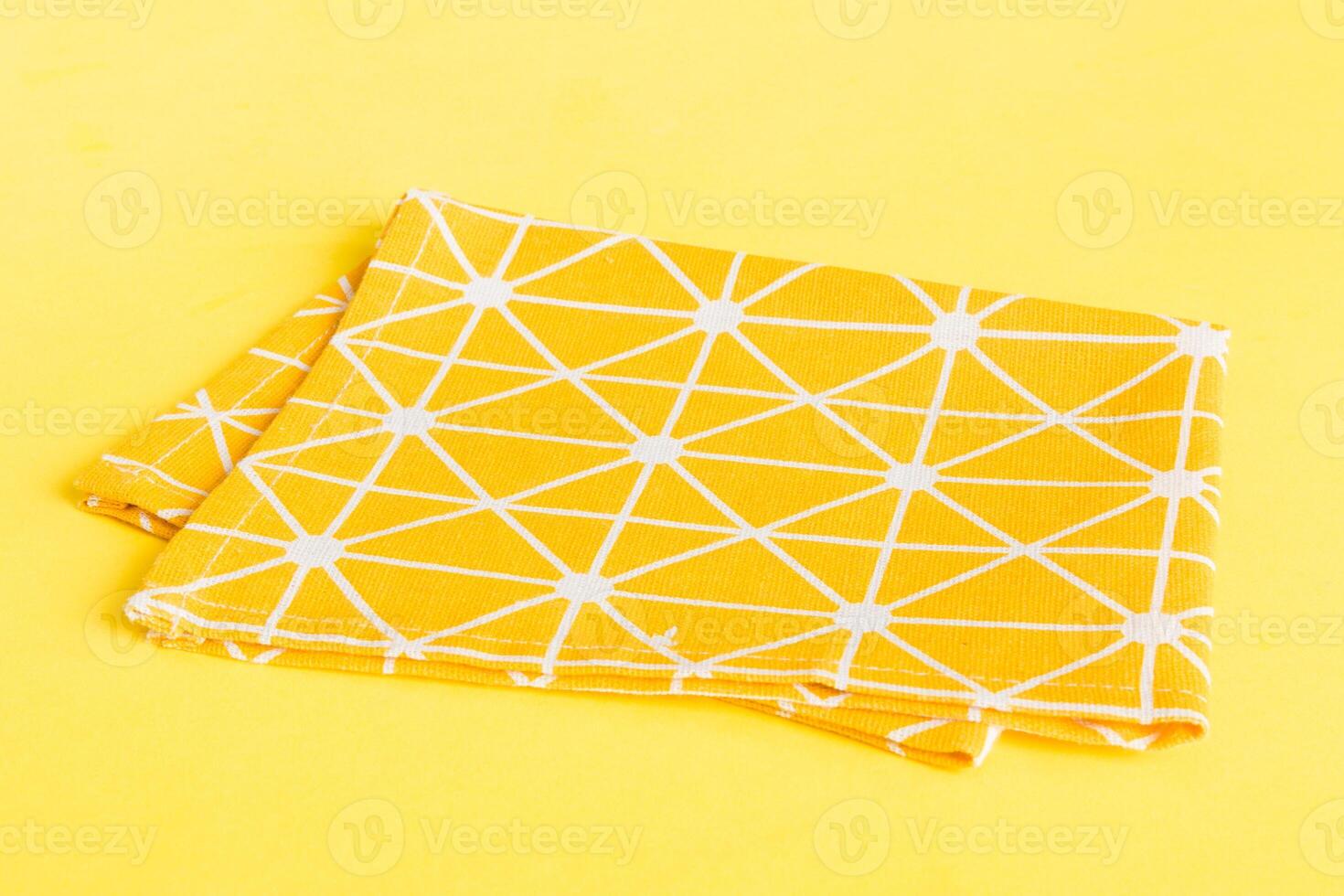 top view with yellow empty kitchen napkin isolated on table background. Folded cloth for mockup with copy space, Flat lay. Minimal style photo