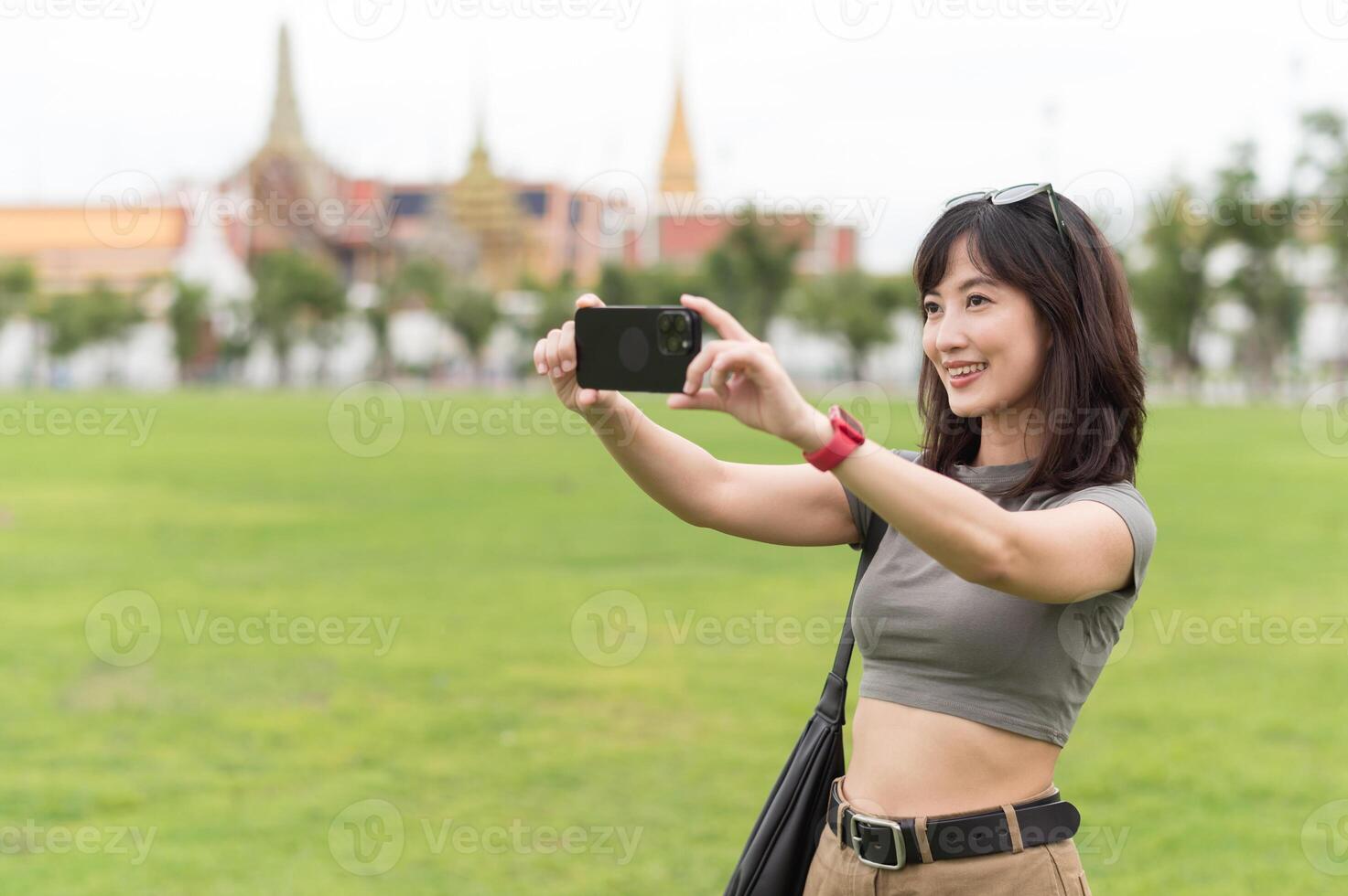 Happy southeast asian woman teenager blogger on solo world travel use smartphone to take photo. local cultural experience for tourism concept for an asia explorer in Bangkok Thailand photo