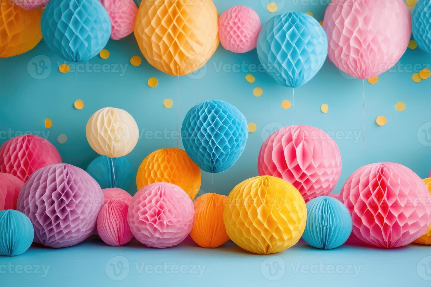 Colorful honeycomb paper balls hanging and resting on blue surface with confetti photo