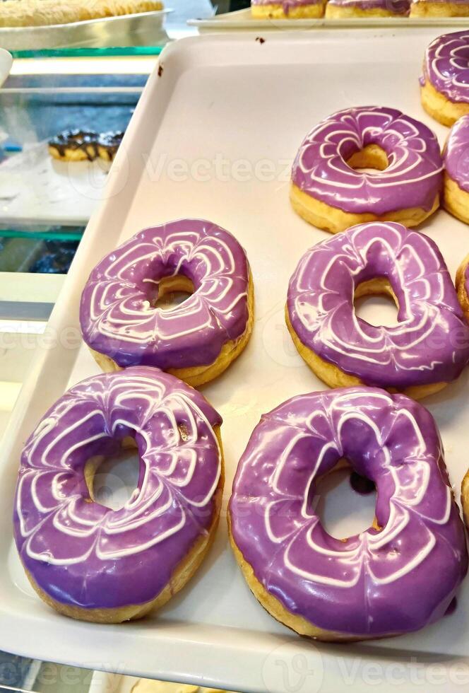 Vibrant Purple Glazed Donuts with White Swirls photo