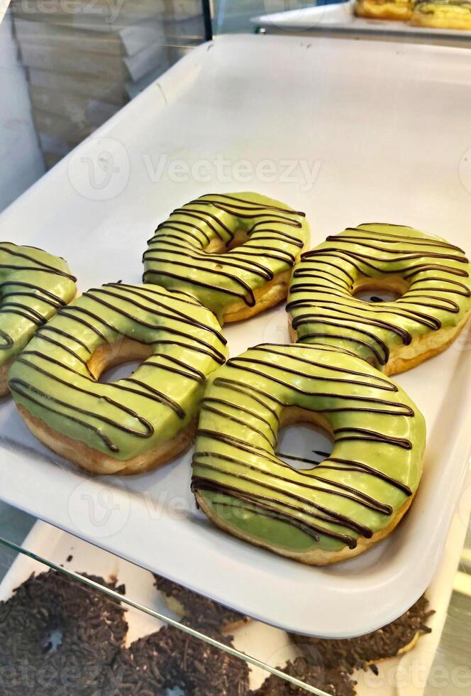 Light Green Glazed Donuts with Chocolate Stripes photo