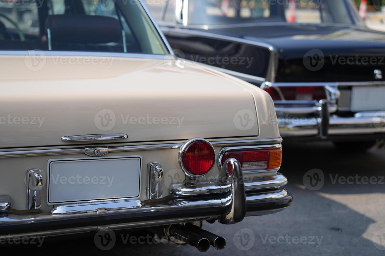 A chrome keyhole above the license plate and a polished rear trunk lock system on a vintage car highlight its sturdy and secure mechanical design.f photo