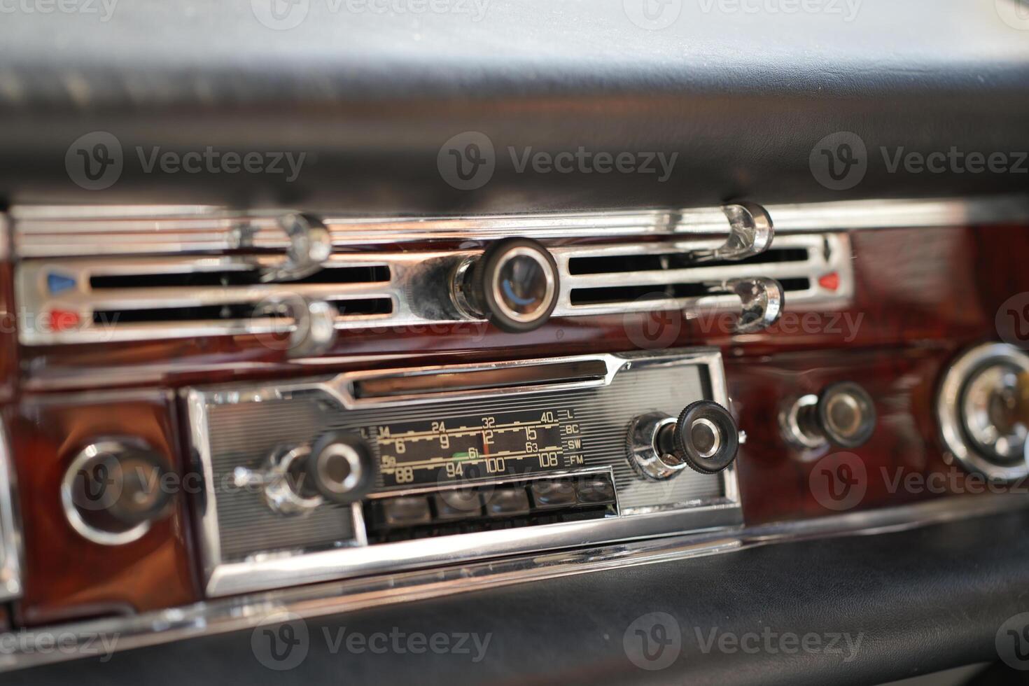 The dashboard of a vintage classic car features detailed analog gauges, a radio, and air vents in polished wood and chrome, offering a fresh yet luxurious look.he photo