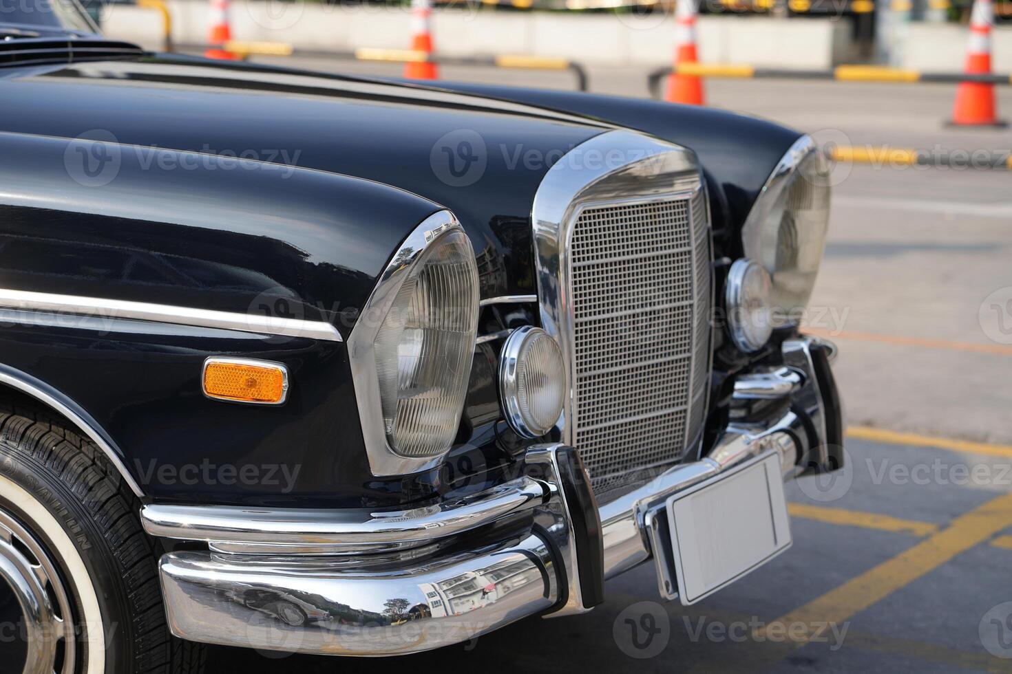 The round headlights and side turn signals on classic cars, framed in polished chrome, highlight the vintage style with old-fashioned lighting and curved fender details.a photo