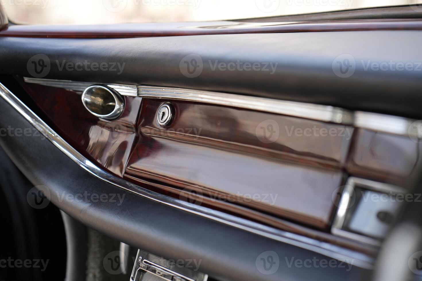 The dashboard of a vintage classic car features detailed analog gauges, a radio, and air vents in polished wood and chrome, offering a fresh yet luxurious look.fg photo