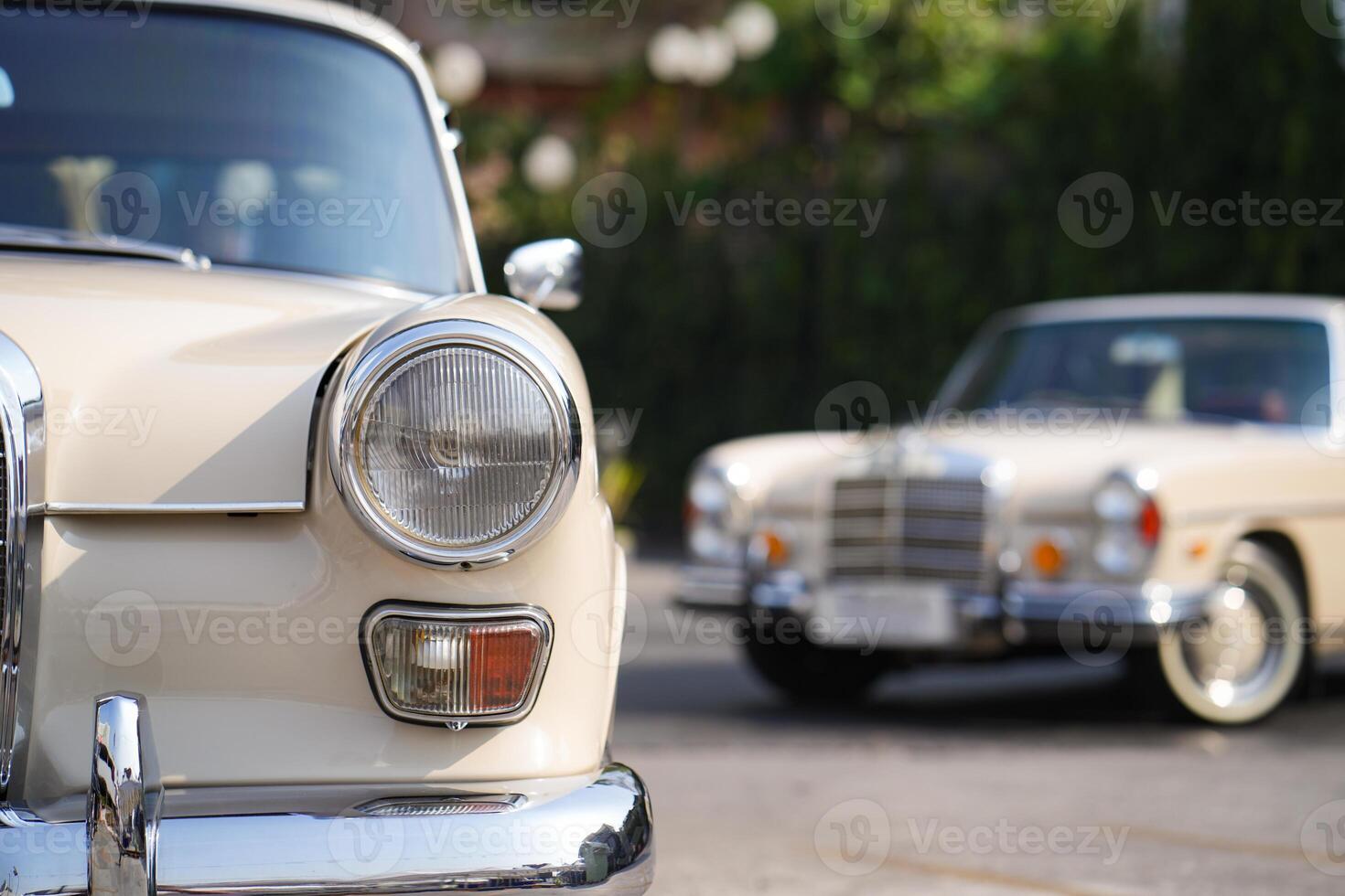 The round headlights and side turn signals on classic cars, framed in polished chrome, highlight the vintage style with old-fashioned lighting and curved fender details.bc photo