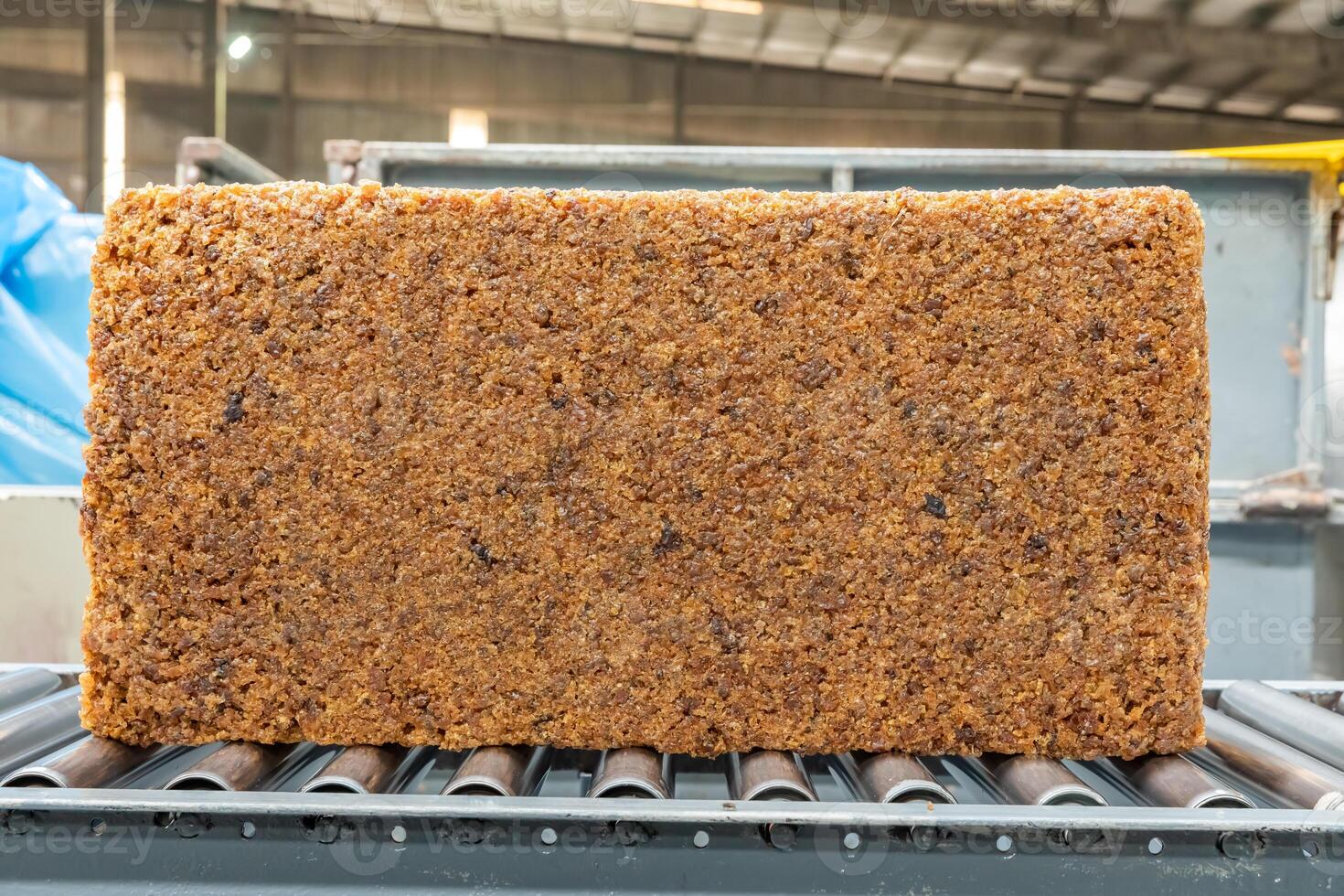 The natural rubber bales products on the industrial automatic conveyor belt machine in a rubber factory.aa photo