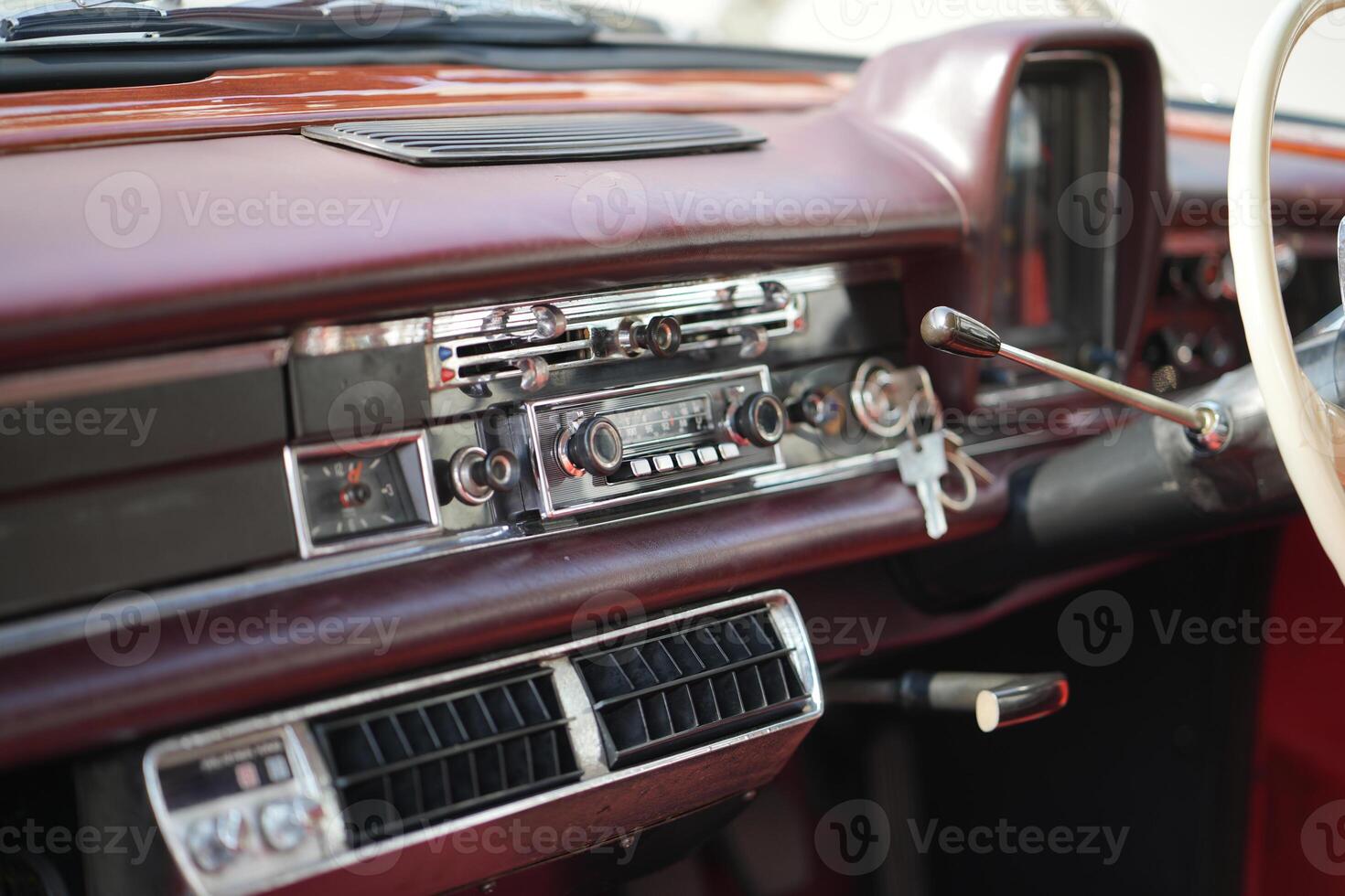 The dashboard of a vintage classic car features detailed analog gauges, a radio, and air vents in polished wood and chrome, offering a fresh yet luxurious look.ha photo