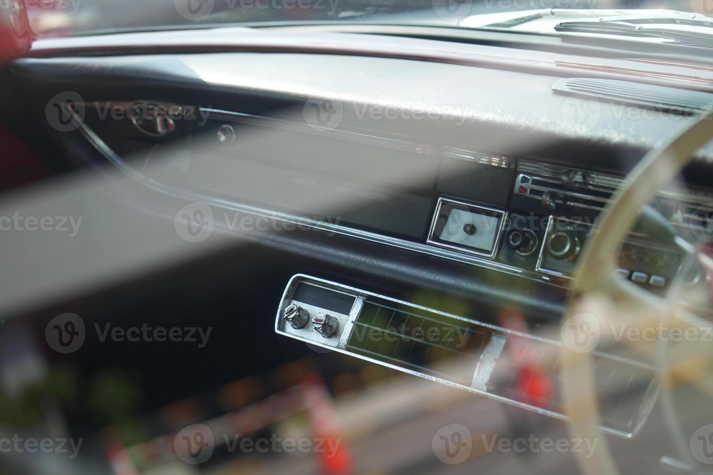 The dashboard of a vintage classic car features detailed analog gauges, a radio, and air vents in polished wood and chrome, offering a fresh yet luxurious look.ec photo