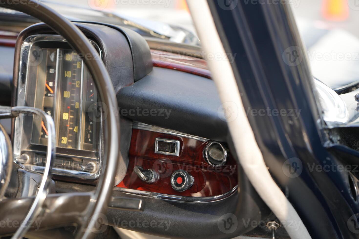 The dashboard of a vintage classic car features detailed analog gauges, a radio, and air vents in polished wood and chrome, offering a fresh yet luxurious look.g photo