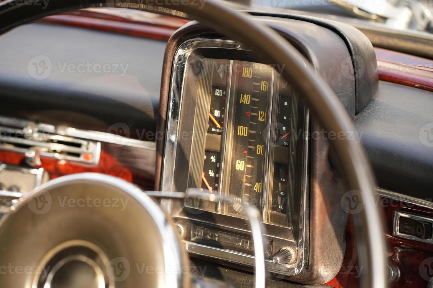 The dashboard of a vintage classic car features detailed analog gauges, a radio, and air vents in polished wood and chrome, offering a fresh yet luxurious look.bdh photo