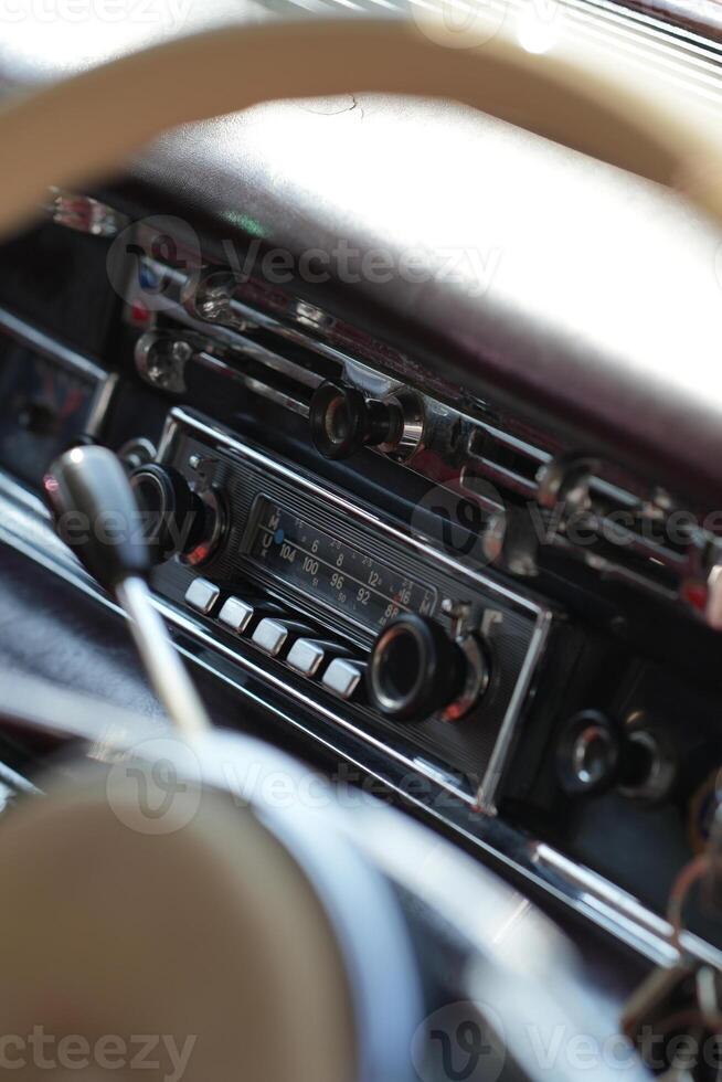 The dashboard of a vintage classic car features detailed analog gauges, a radio, and air vents in polished wood and chrome, offering a fresh yet luxurious look.ag photo