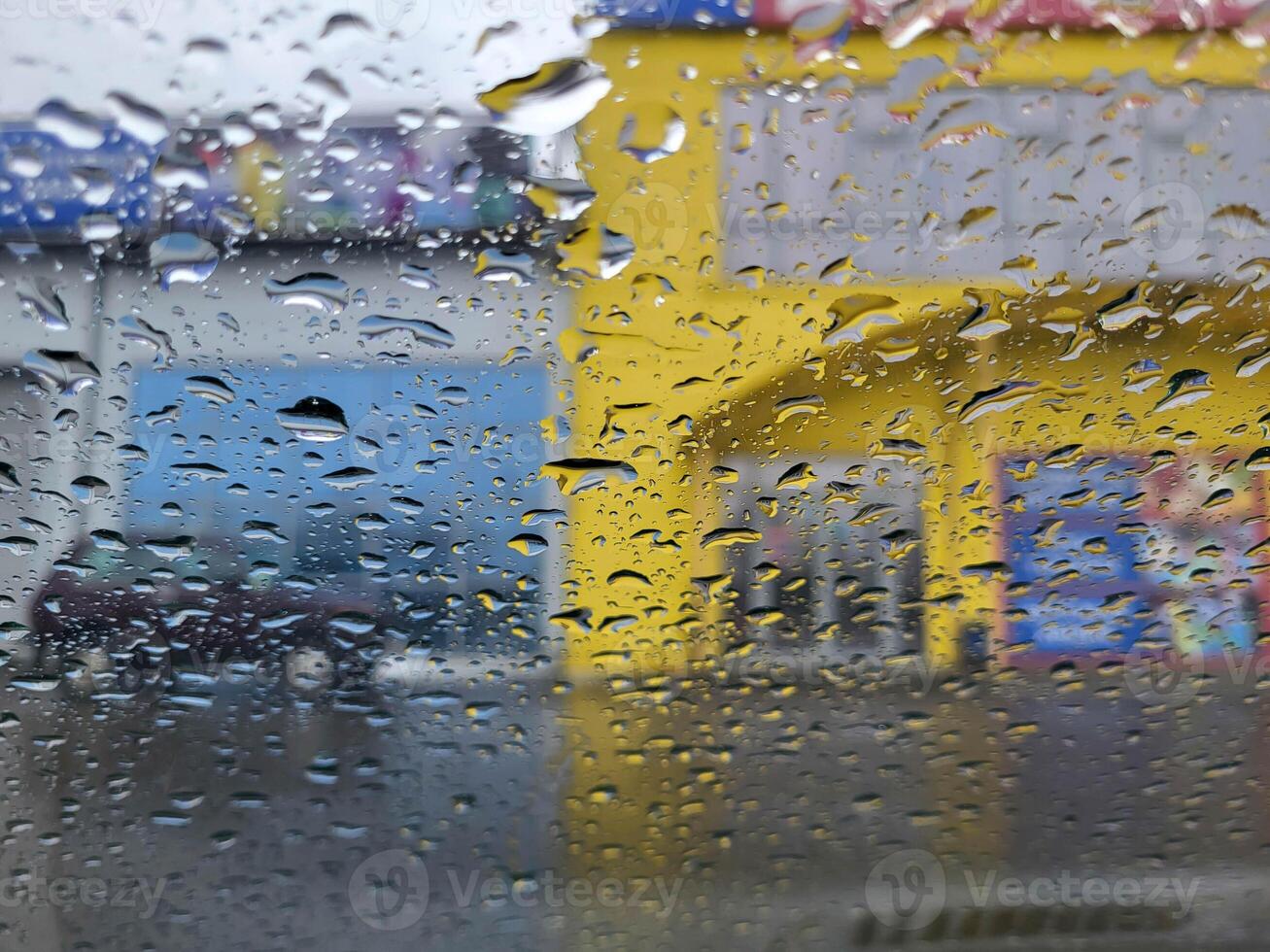 View through a rain-soaked window at a blurred background with houses photo