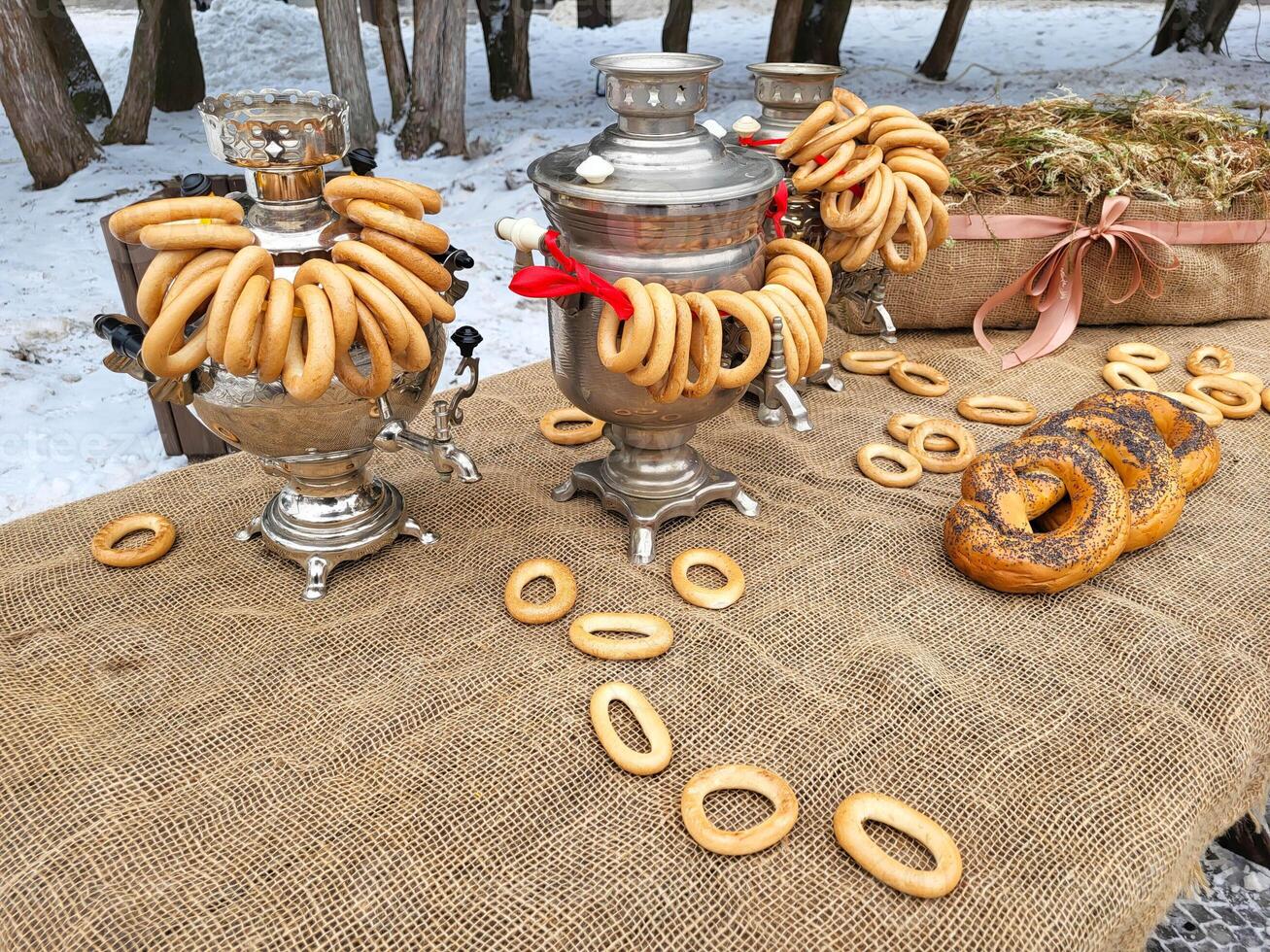 During the celebration of Maslenitsa. There are poppy seed rogues on a table covered with burlap. And there are three samovars photo