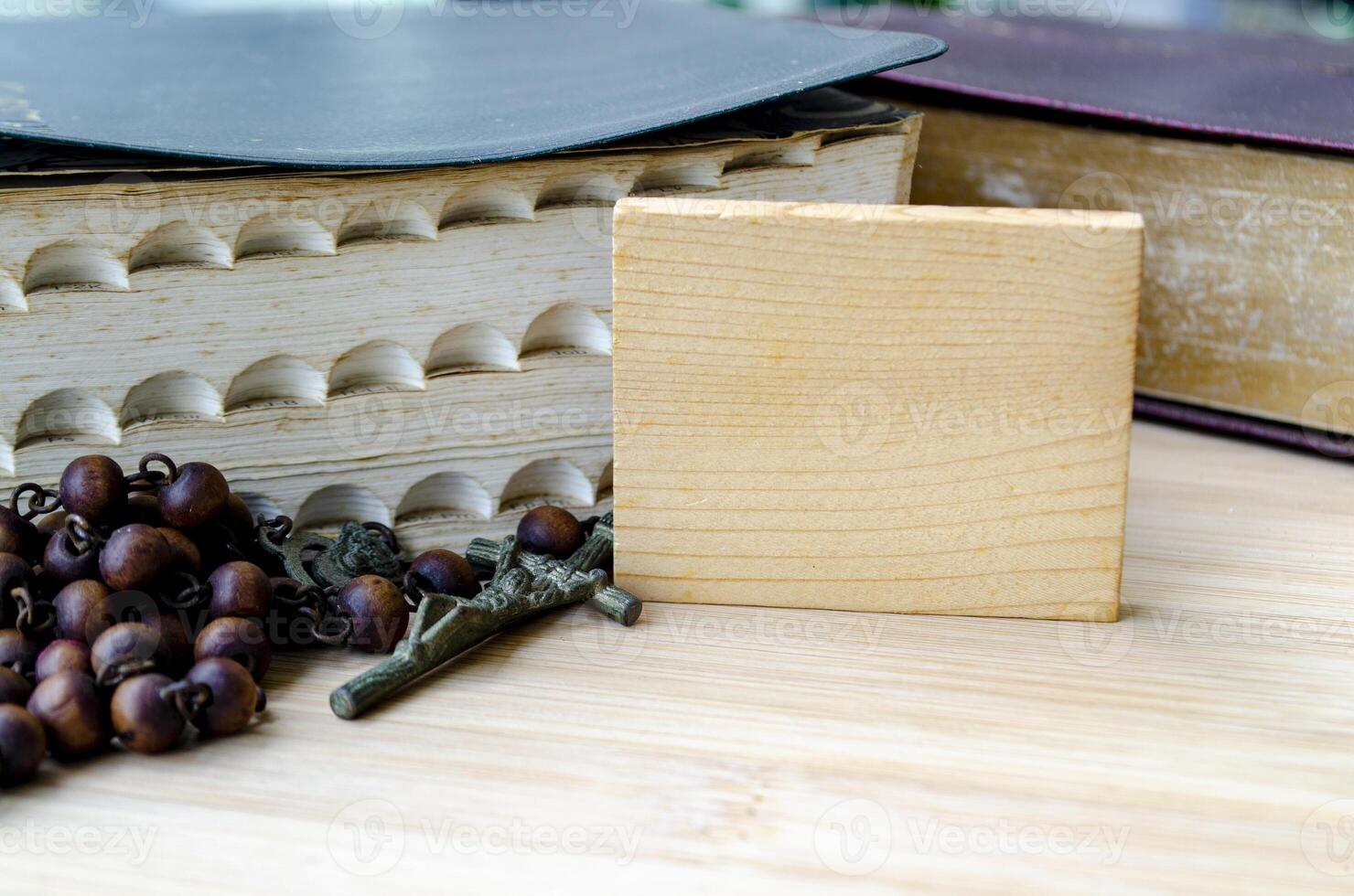 Wooden block with customizable space for text or message sharing. With Holy Bible and Holy Rosary background photo