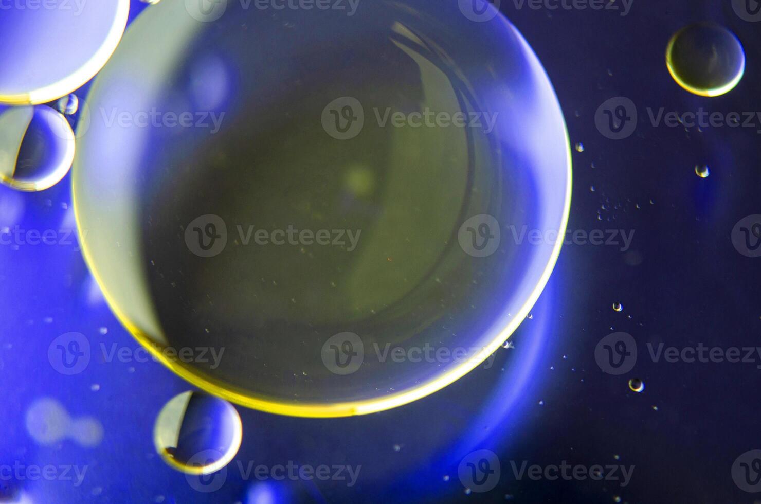 Top view of extreme close up of oil bubbles with gradient light yellow background photo